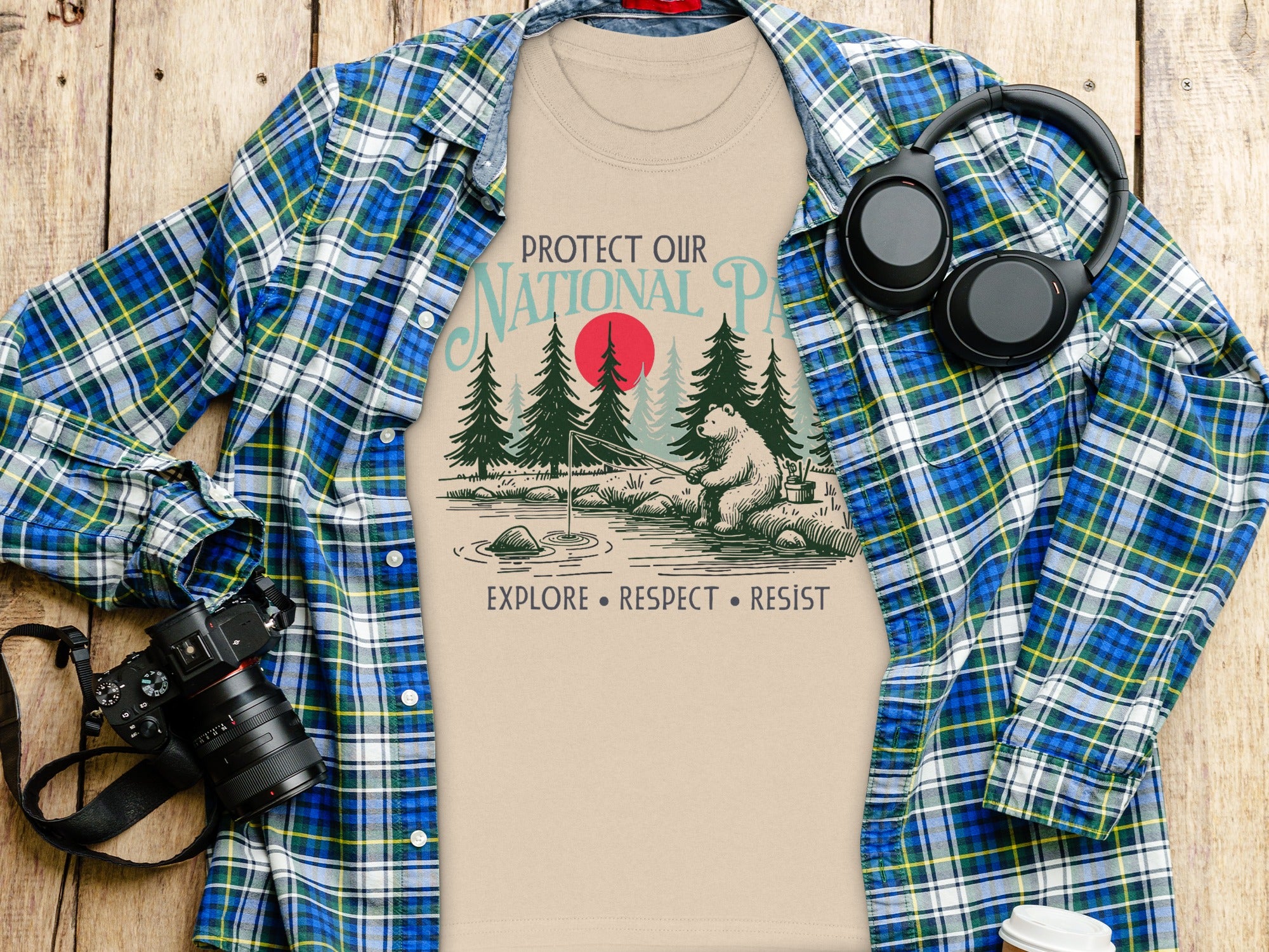 T-shirt with "Protect Our National Parks" text and bear fishing graphic, surrounded by items.