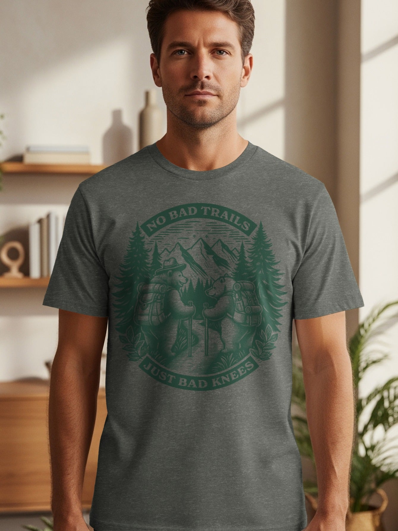Dark gray t-shirt with green graphic of two bears hiking and text "NO BAD TRAILS JUST BAD KNEES".