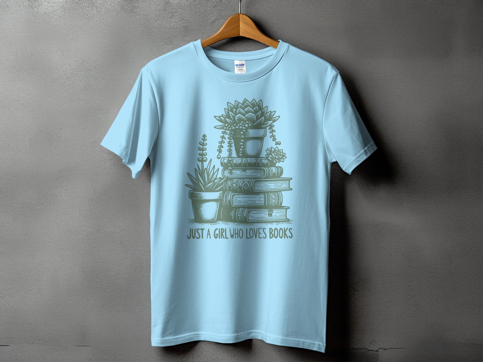 Light blue t-shirt with stacked books and potted succulents graphic, text reads "JUST A GIRL WHO LOVES BOOKS".