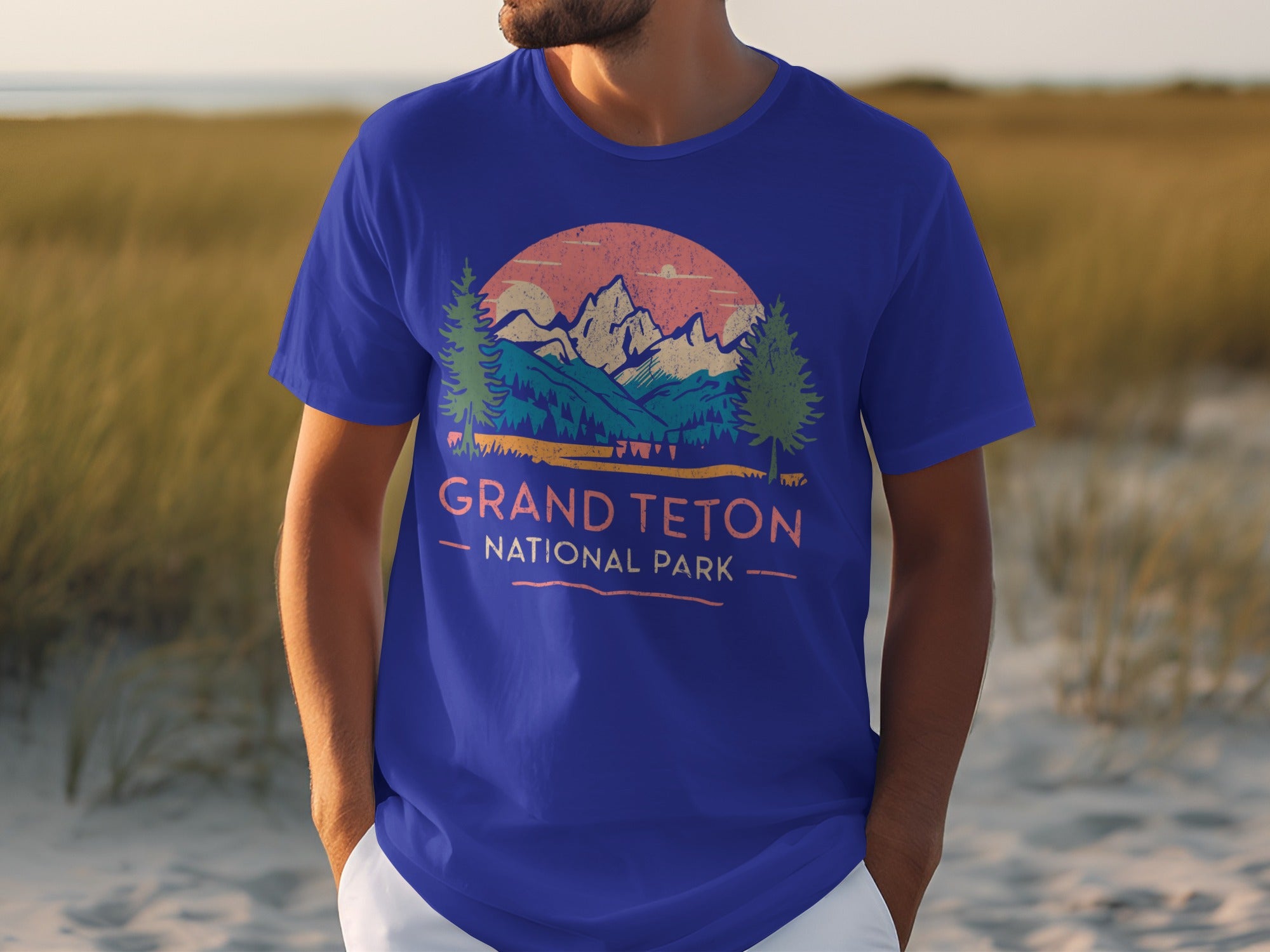 Royal blue t-shirt with "Grand Teton National Park" graphic and mountain sunset scene.