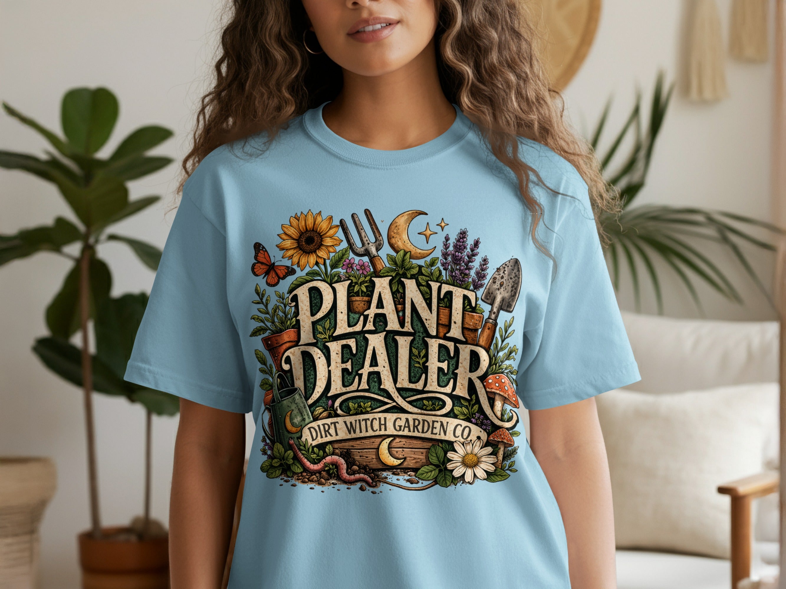 Light blue t-shirt with "PLANT DEALER DIRT WITCH GARDEN CO." text and garden imagery.