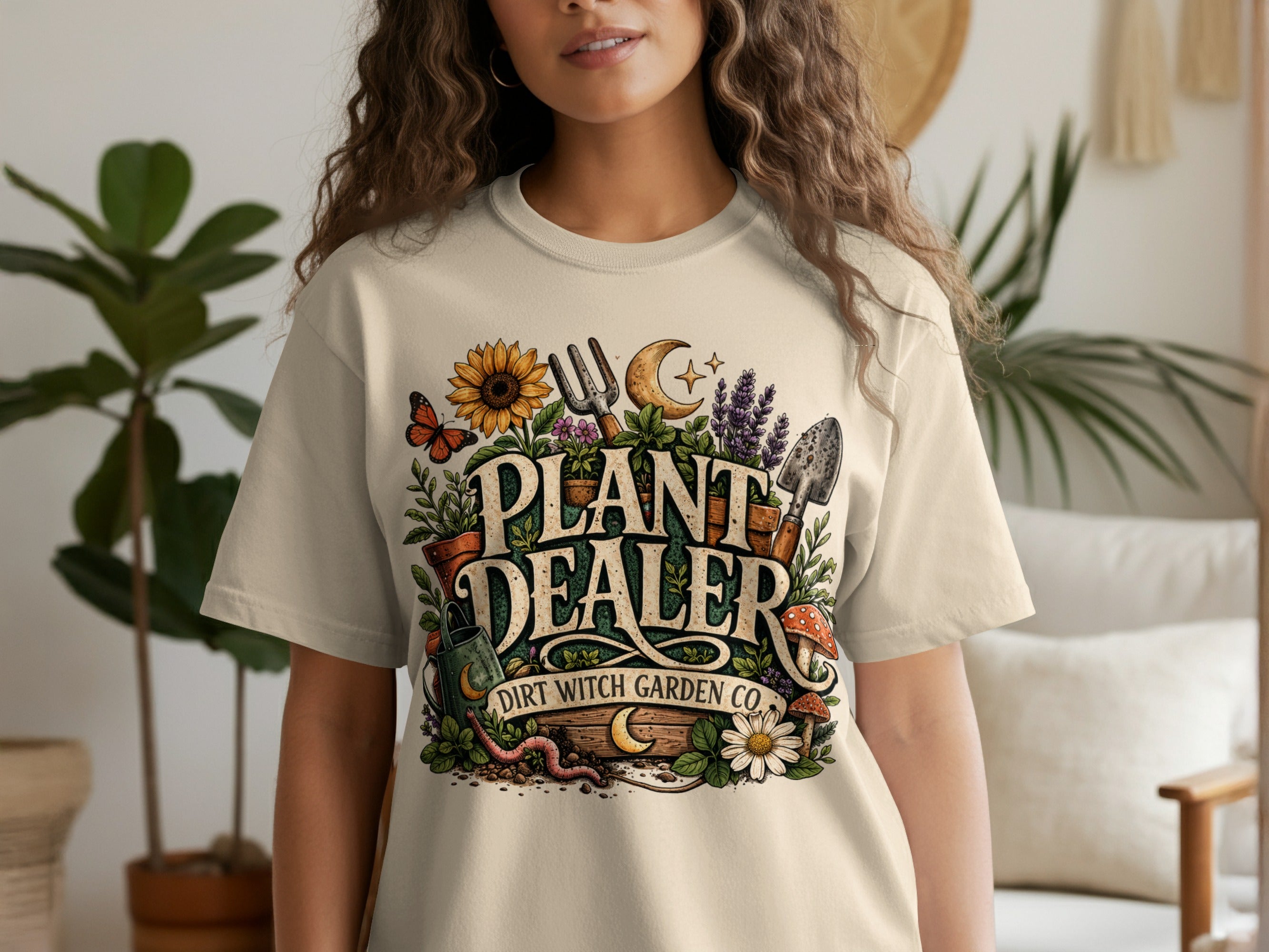 Plant Dealer Dirt Witch Garden Co. graphic on a beige t-shirt with gardening and nature elements.