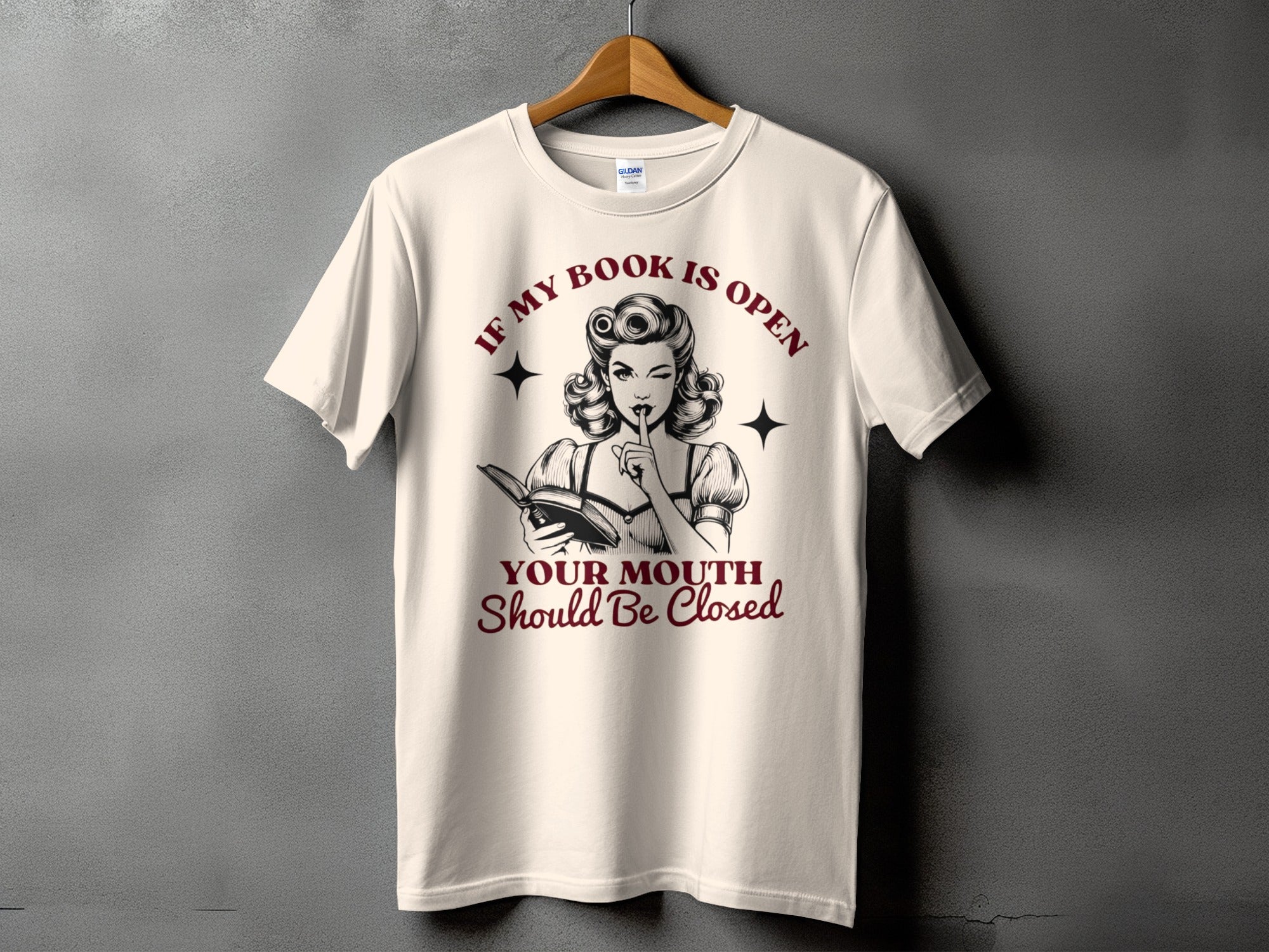 T-shirt with text "If My Book is Open Your Mouth Should Be Closed" and a pin-up style woman.