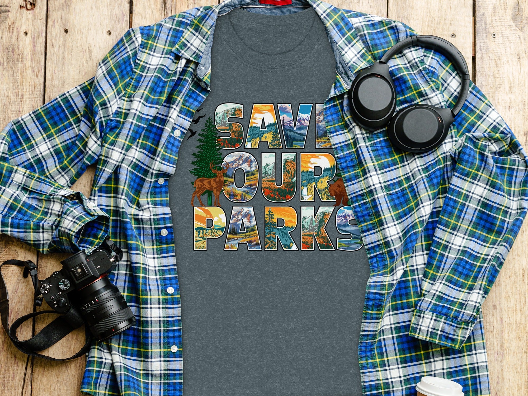 Gray t-shirt with "Save Our Parks" text featuring nature scenes, layered with a plaid shirt.