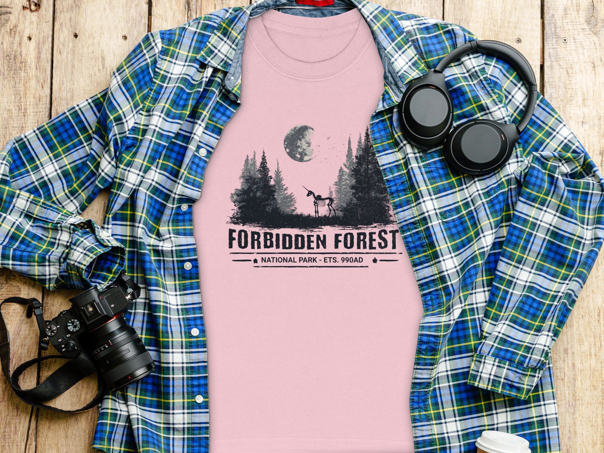 Pink t-shirt with "Forbidden Forest National Park" graphic and skeletal unicorn.