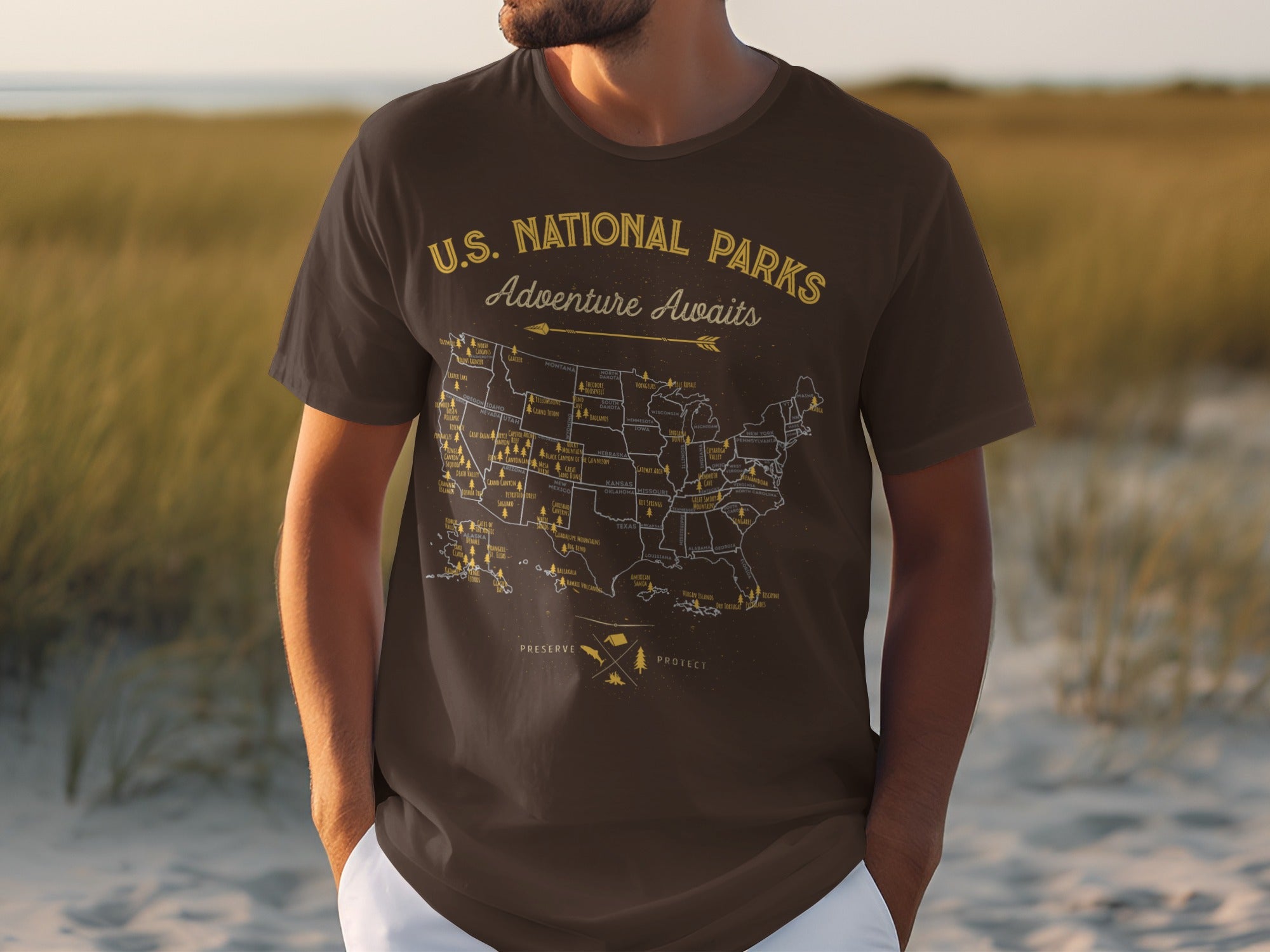 Brown t-shirt with a U.S. map featuring national parks and "Adventure Awaits" text.
