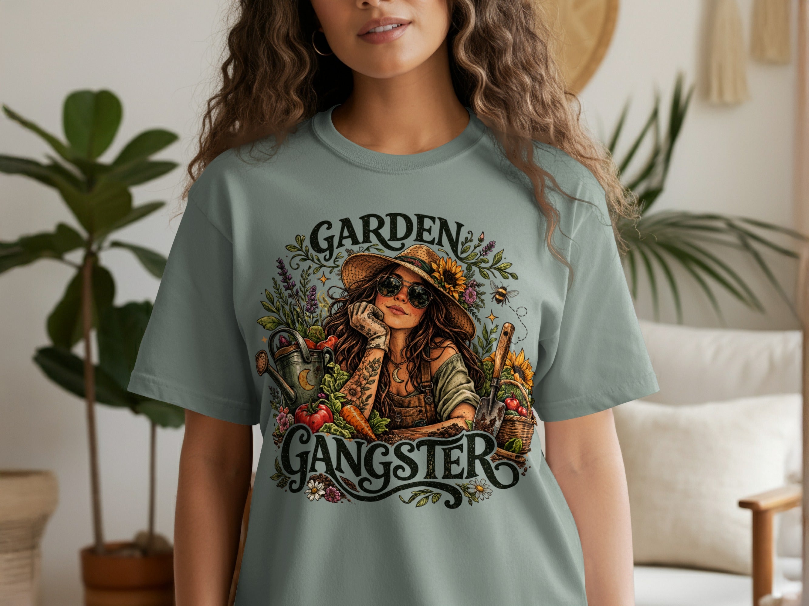 T-shirt graphic of "Garden Gangster" with woman, garden tools, and fresh produce.