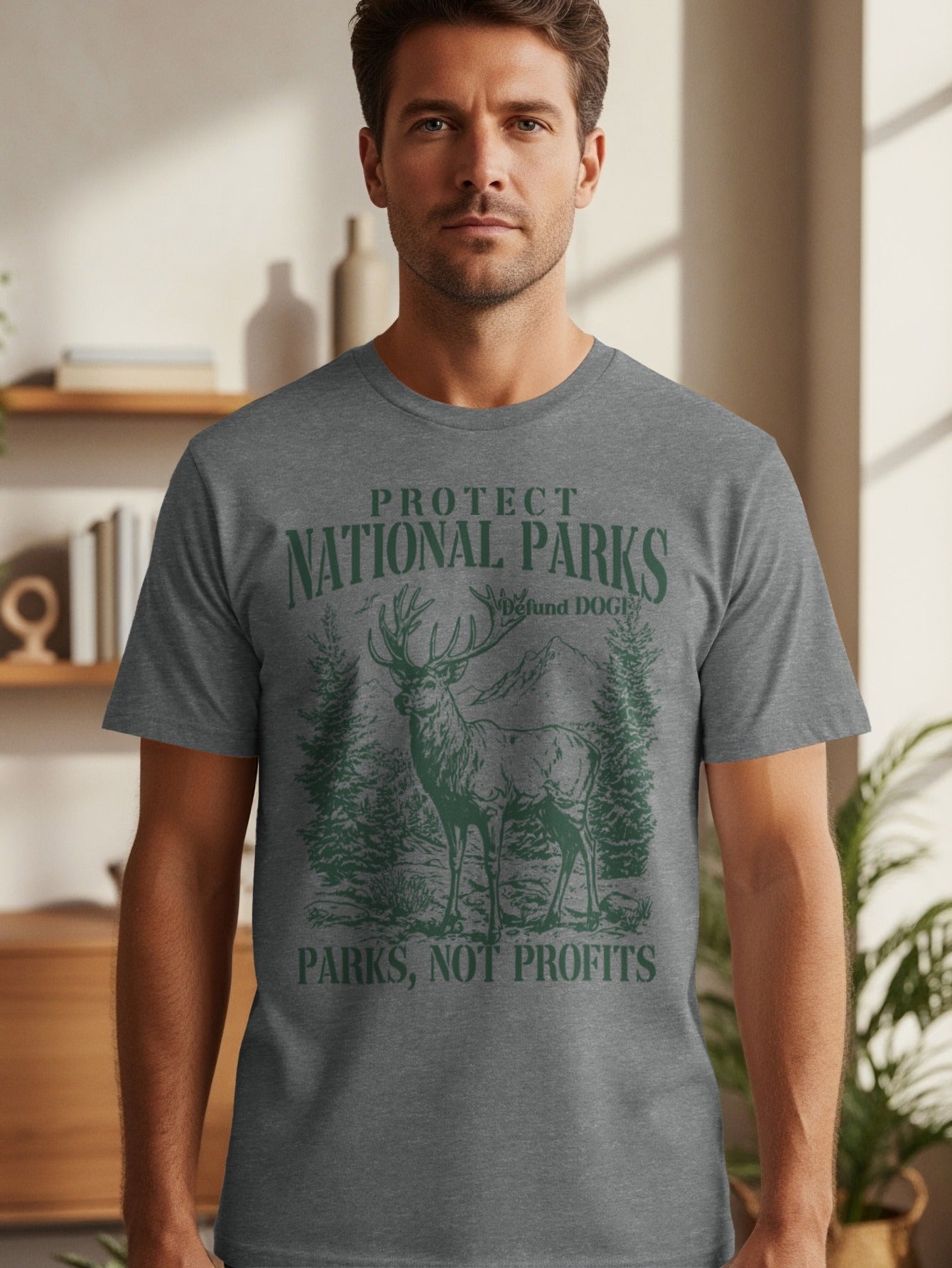 Grey t-shirt with deer, trees, mountains, and text: Protect National Parks, Defund DOGE, Parks, Not Profits.