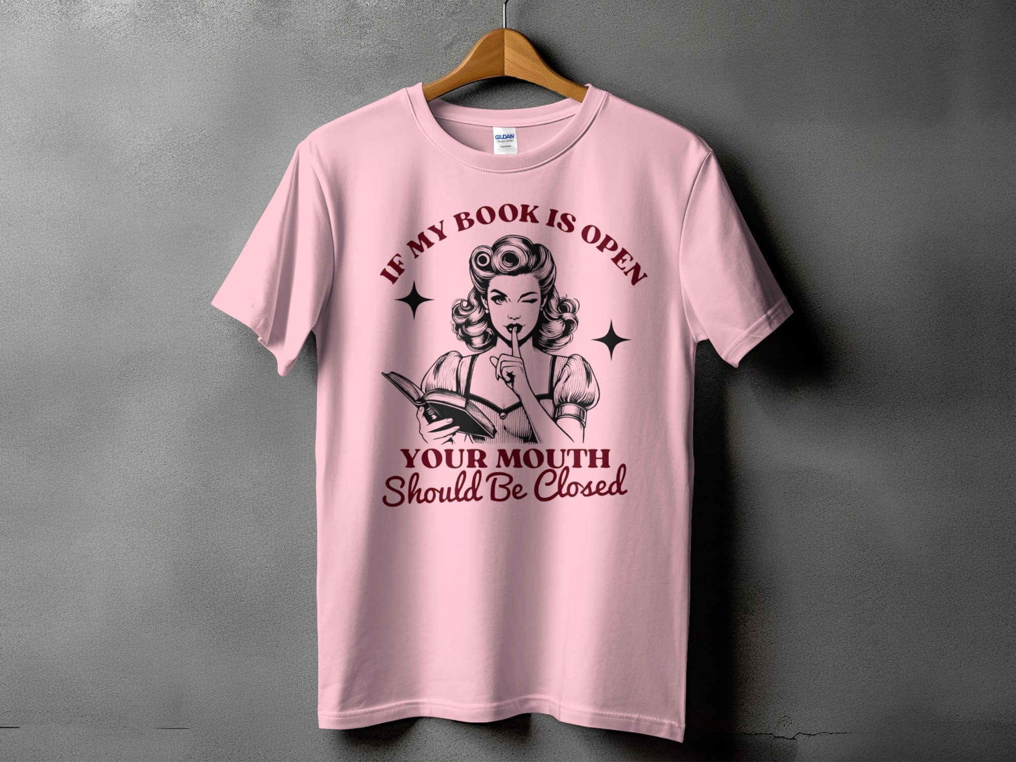 Pink t-shirt with "If My Book Is Open, Your Mouth Should Be Closed" text and pin-up girl graphic.