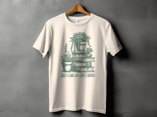 Cream t-shirt with green graphic of potted succulents on stacked books and text "JUST A GIRL WHO LOVES BOOKS".