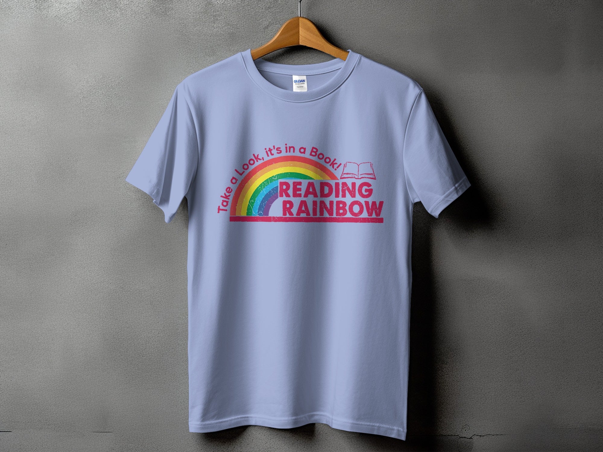 Light blue t-shirt with rainbow graphic and text "Take a Look, it's in a Book! READING RAINBOW".