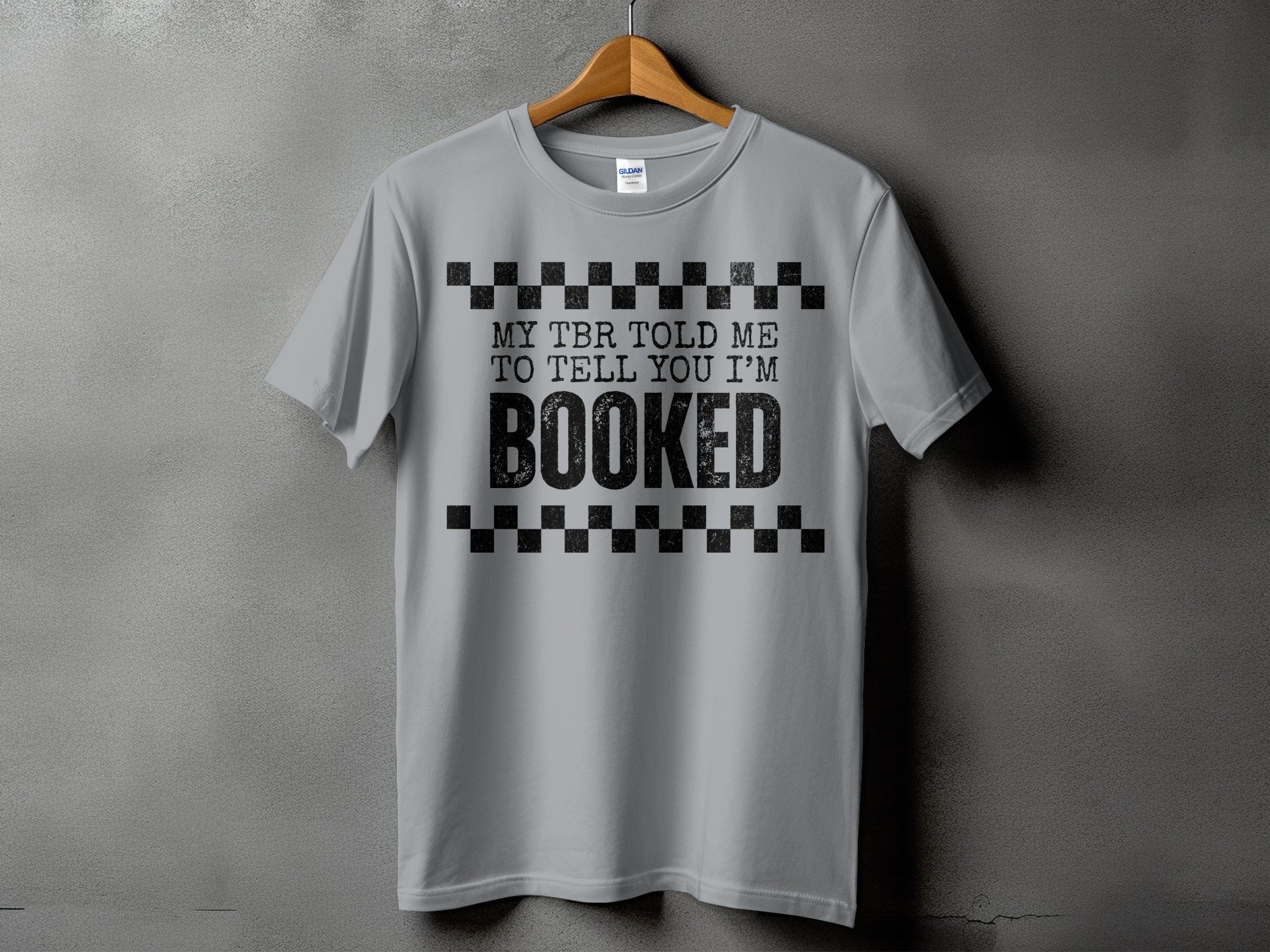 Grey T-shirt with black text "MY TBR TOLD ME TO TELL YOU I'M BOOKED".