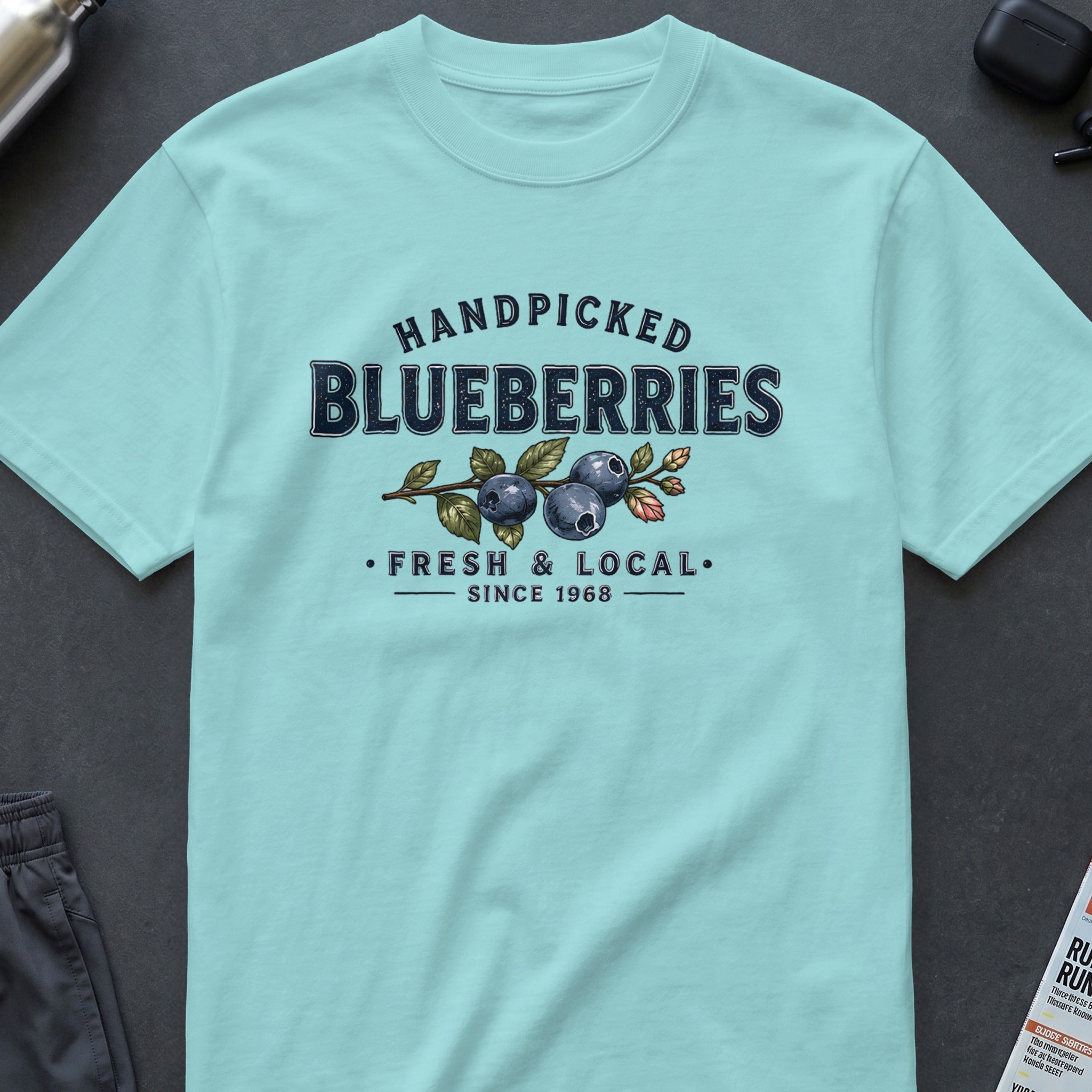 Light blue t-shirt with "Handpicked Blueberries Fresh & Local Since 1968" graphic.