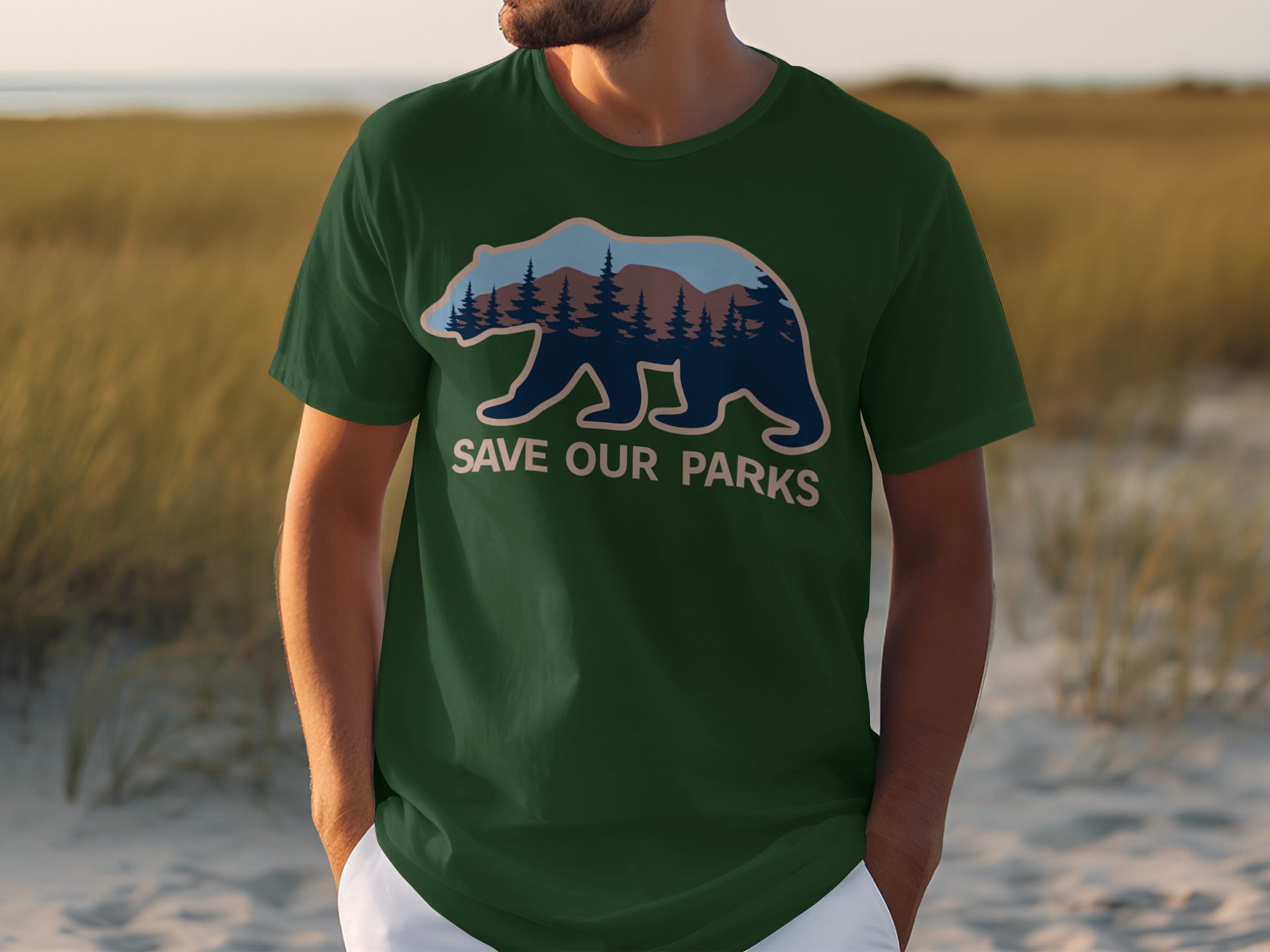Green t-shirt with a bear graphic containing a forest and mountains, and text "SAVE OUR PARKS".