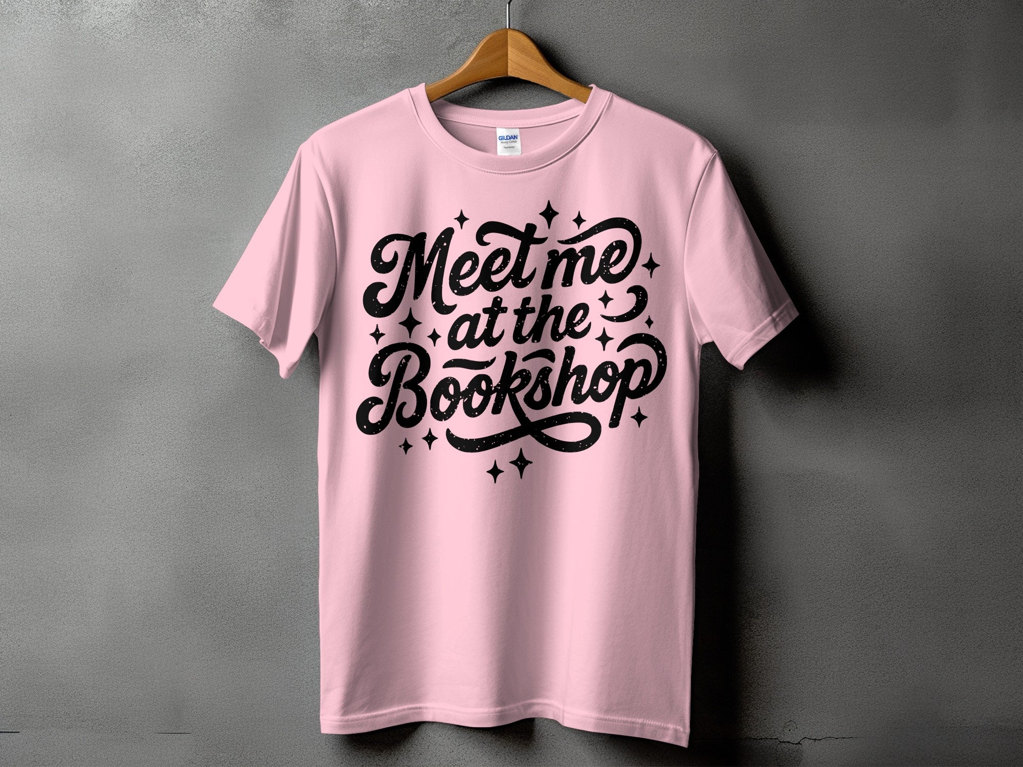 Pink t-shirt with black "Meet me at the Bookshop" text and stars.