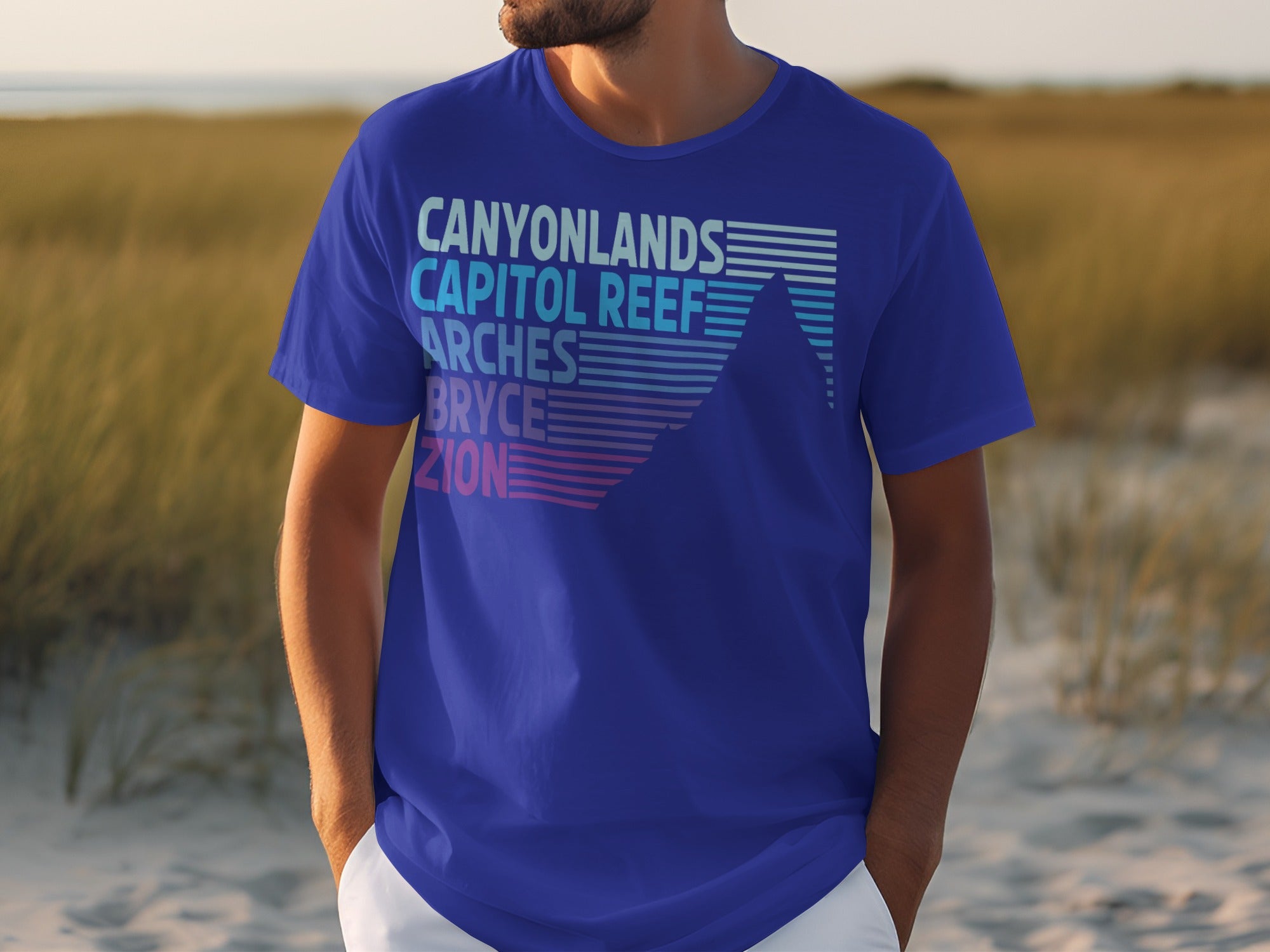 Blue t-shirt with Canyonlands, Capitol Reef, Arches, Bryce, Zion list and mountain graphic.