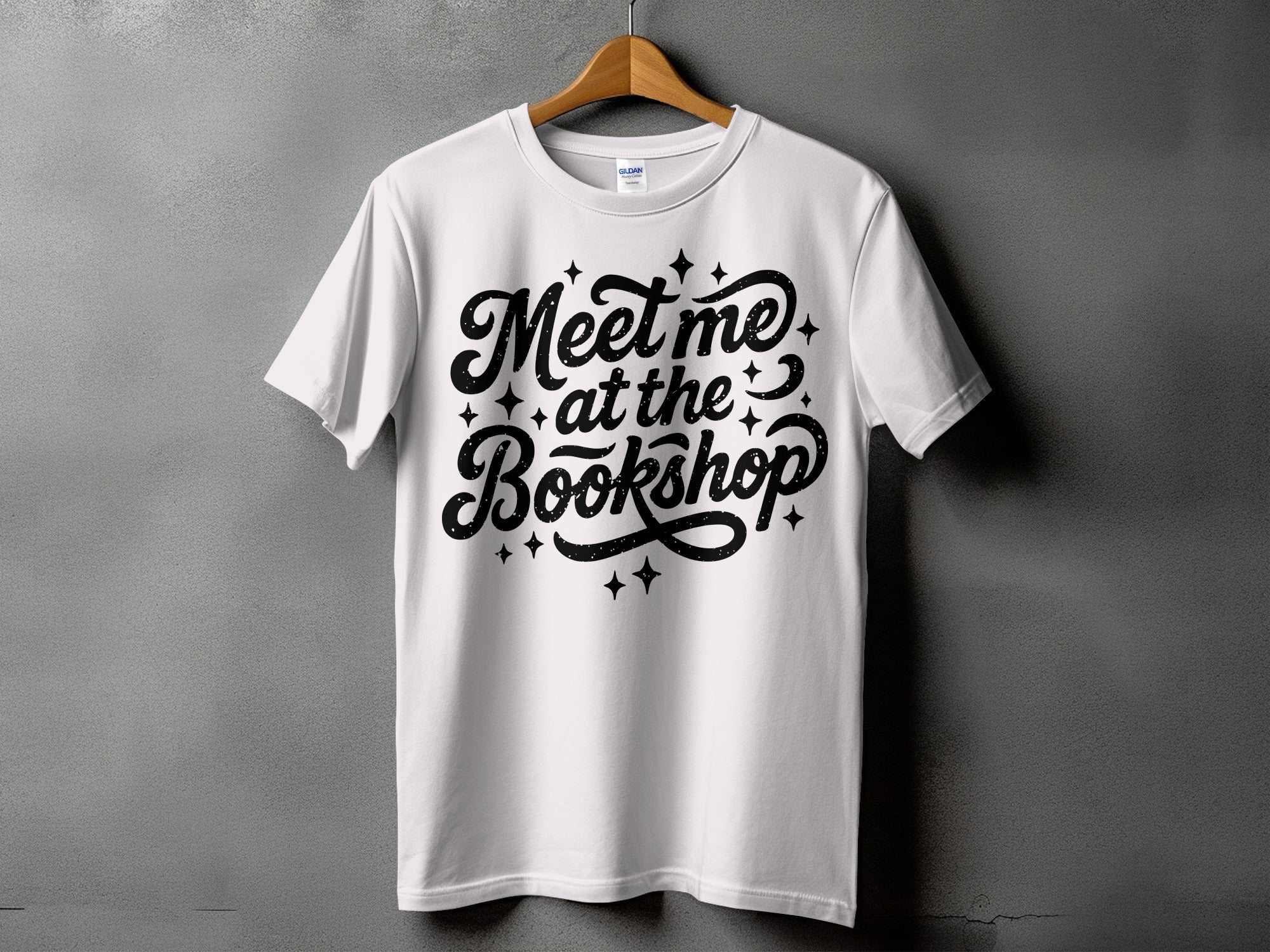 White t-shirt with black text and stars that reads "Meet me at the Bookshop."