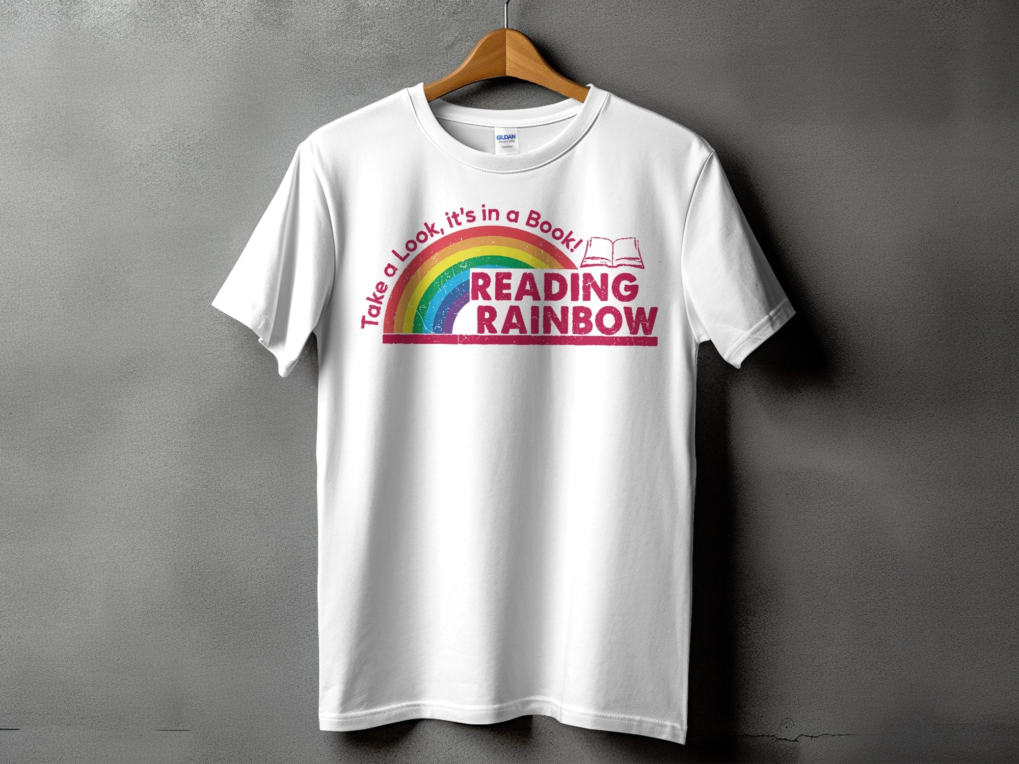 White t-shirt with rainbow and text "Take a Look, it's in a Book! READING RAINBOW".