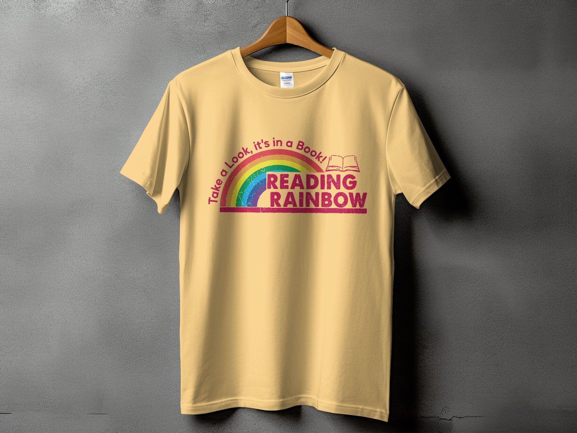 Yellow t-shirt with rainbow graphic and text "Take a Look, it's in a Book! READING RAINBOW"