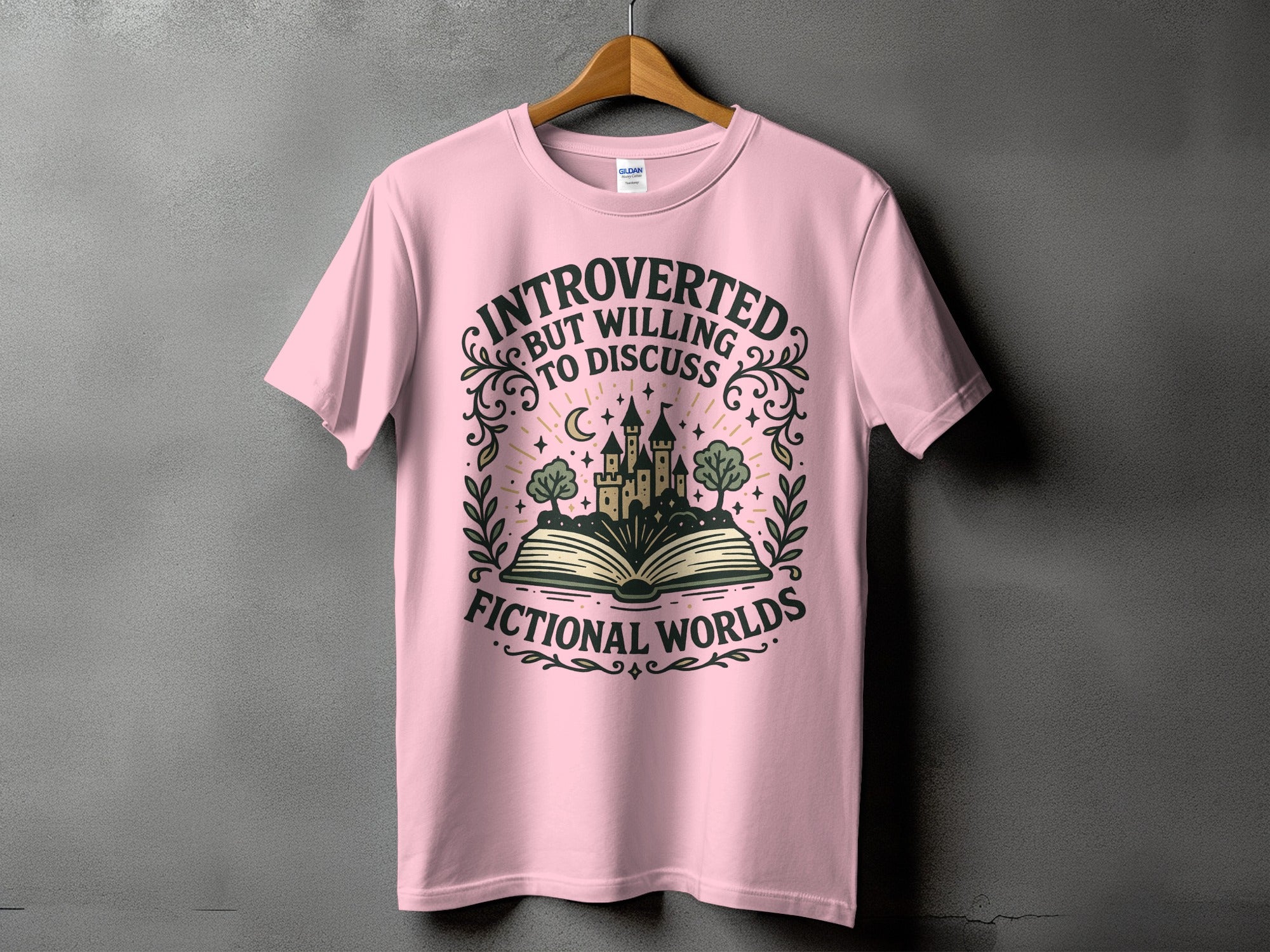 Pink t-shirt with text "Introverted but willing to discuss fictional worlds" and castle on book design.
