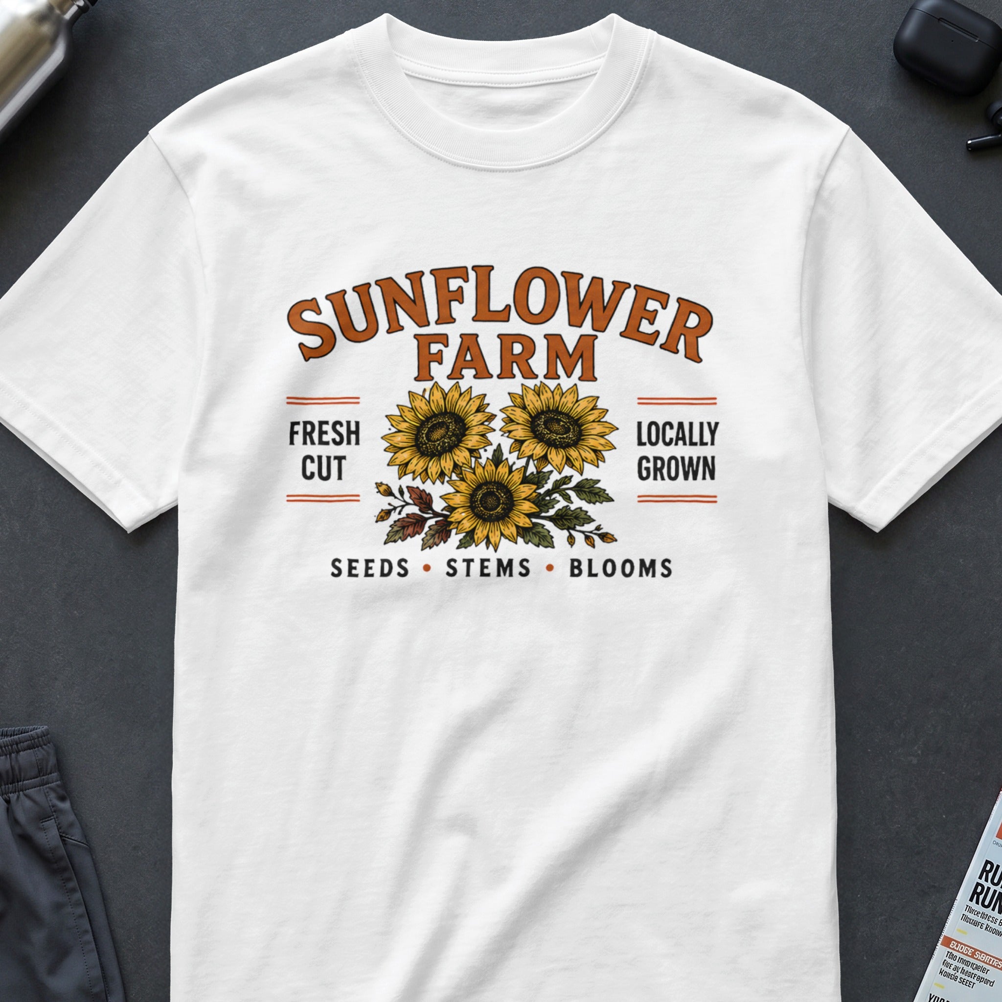 White t-shirt with "Sunflower Farm" and sunflowers graphic, "Fresh Cut Locally Grown", "Seeds Stems Blooms".