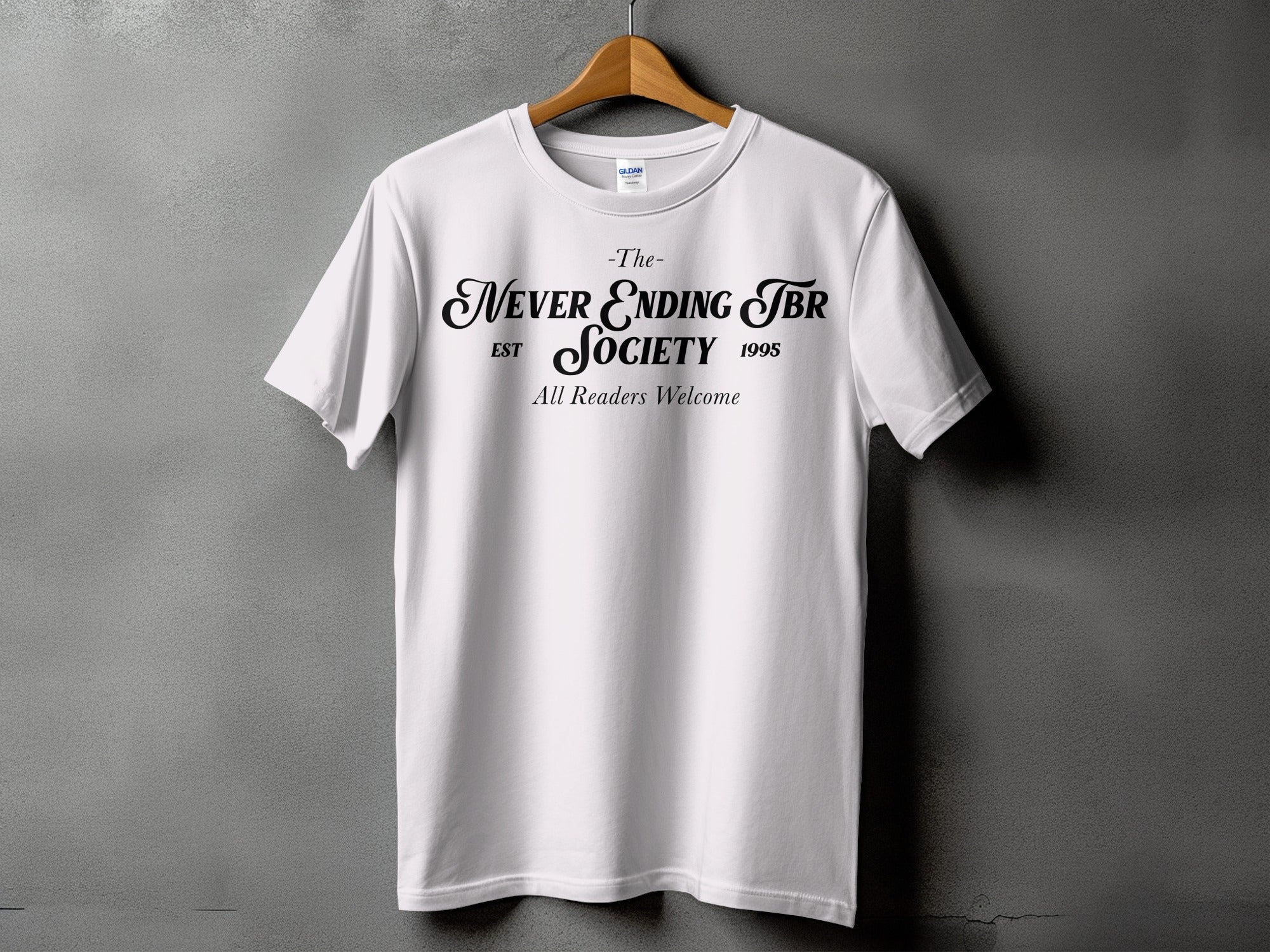White t-shirt with "The- Never Ending TBR Society EST 1995 All Readers Welcome" printed on front.