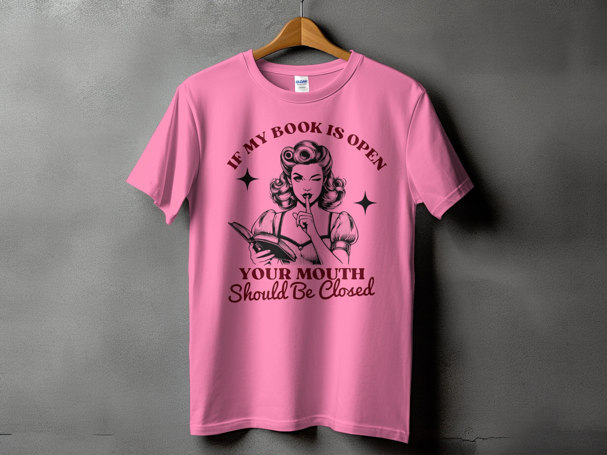 Pink t-shirt with graphic saying "If My Book Is Open, Your Mouth Should Be Closed".