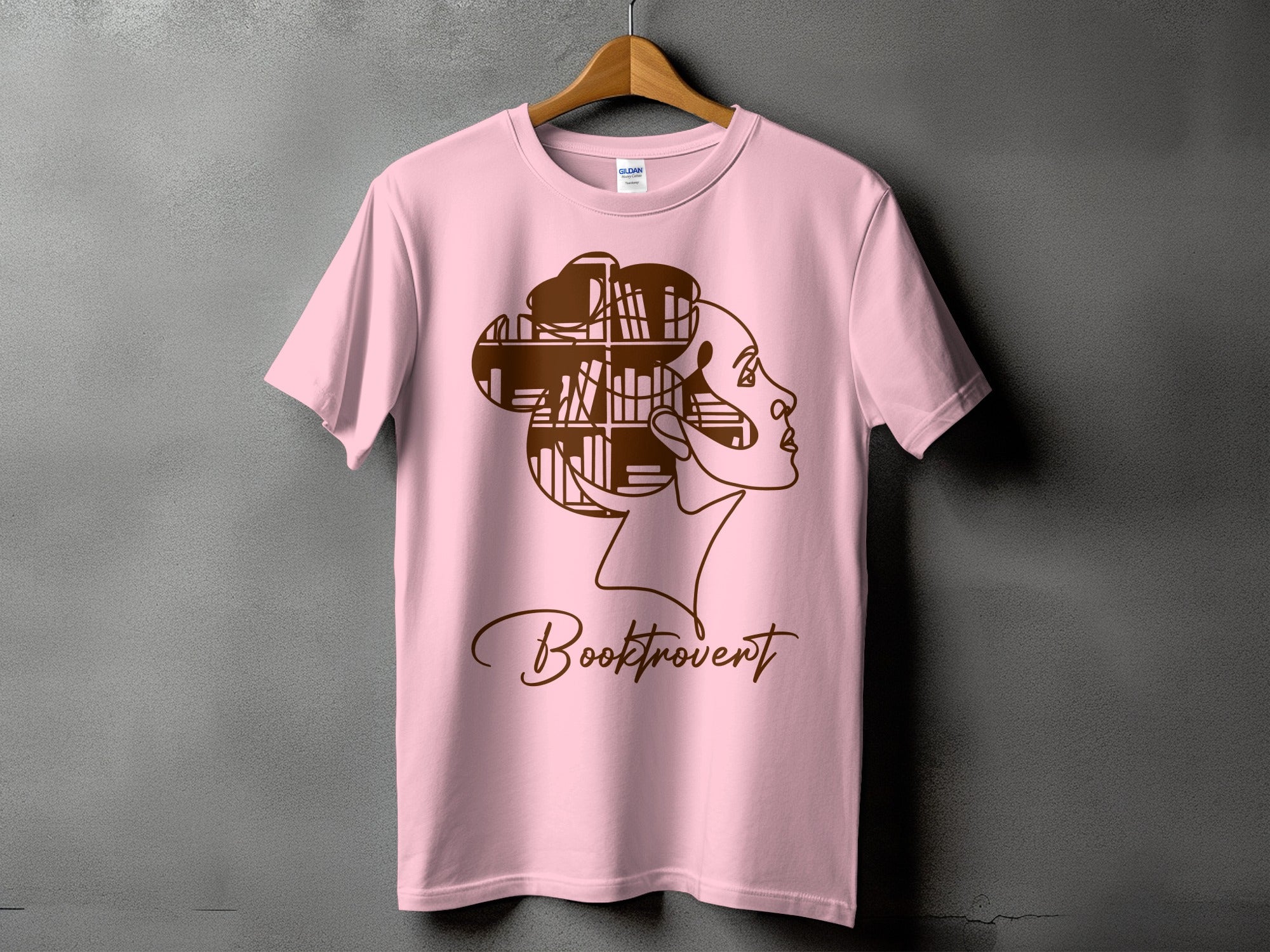 Pink t-shirt with "Booktrovert" text and a profile silhouette of a woman's head filled with books.