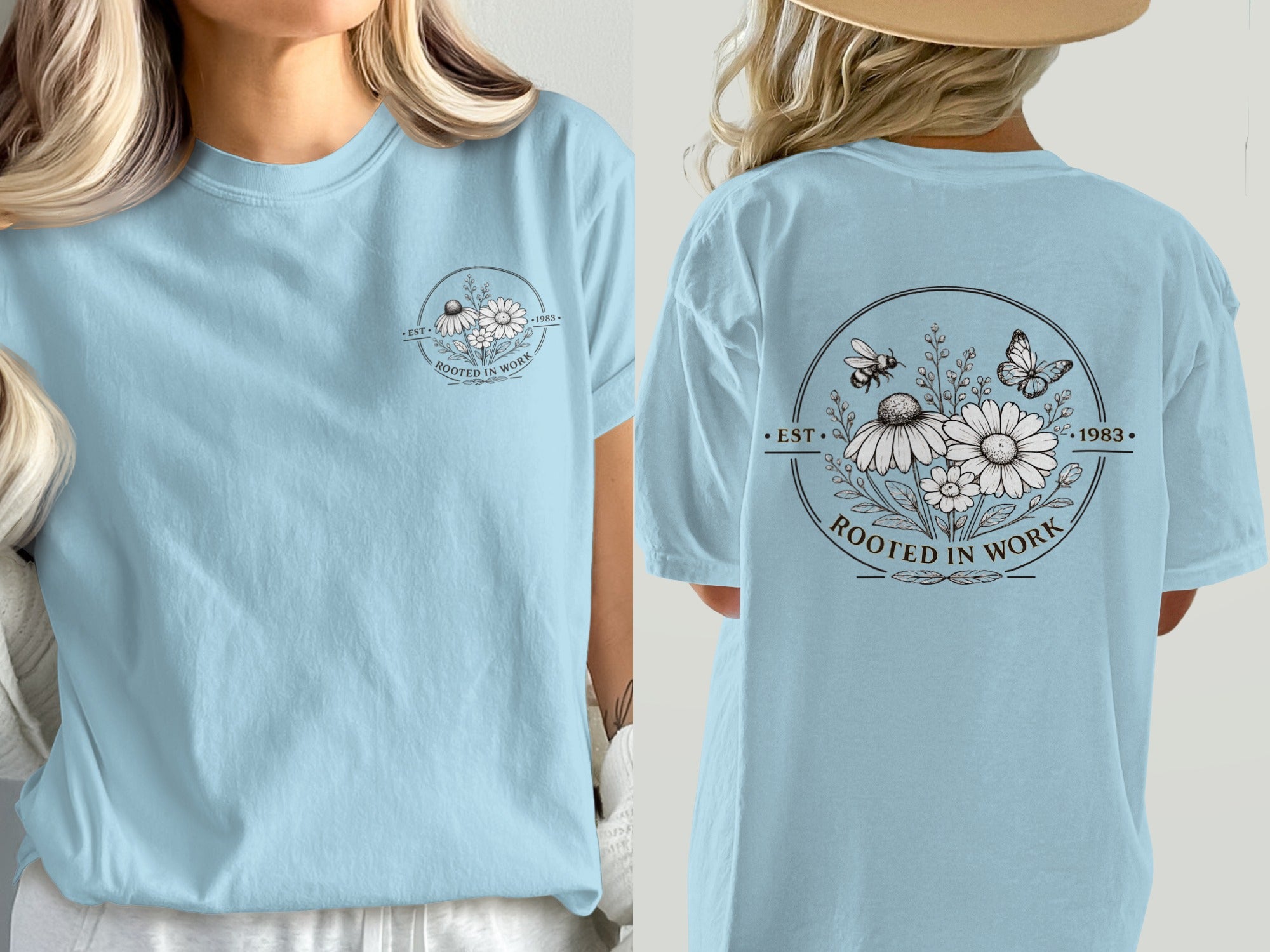 Light blue t-shirt with a circular floral design featuring bees, butterflies, and "Rooted in Work."
