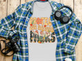 Grey t-shirt with "PROTEC OUR NATIONAL PARKS" graphic and floral details.