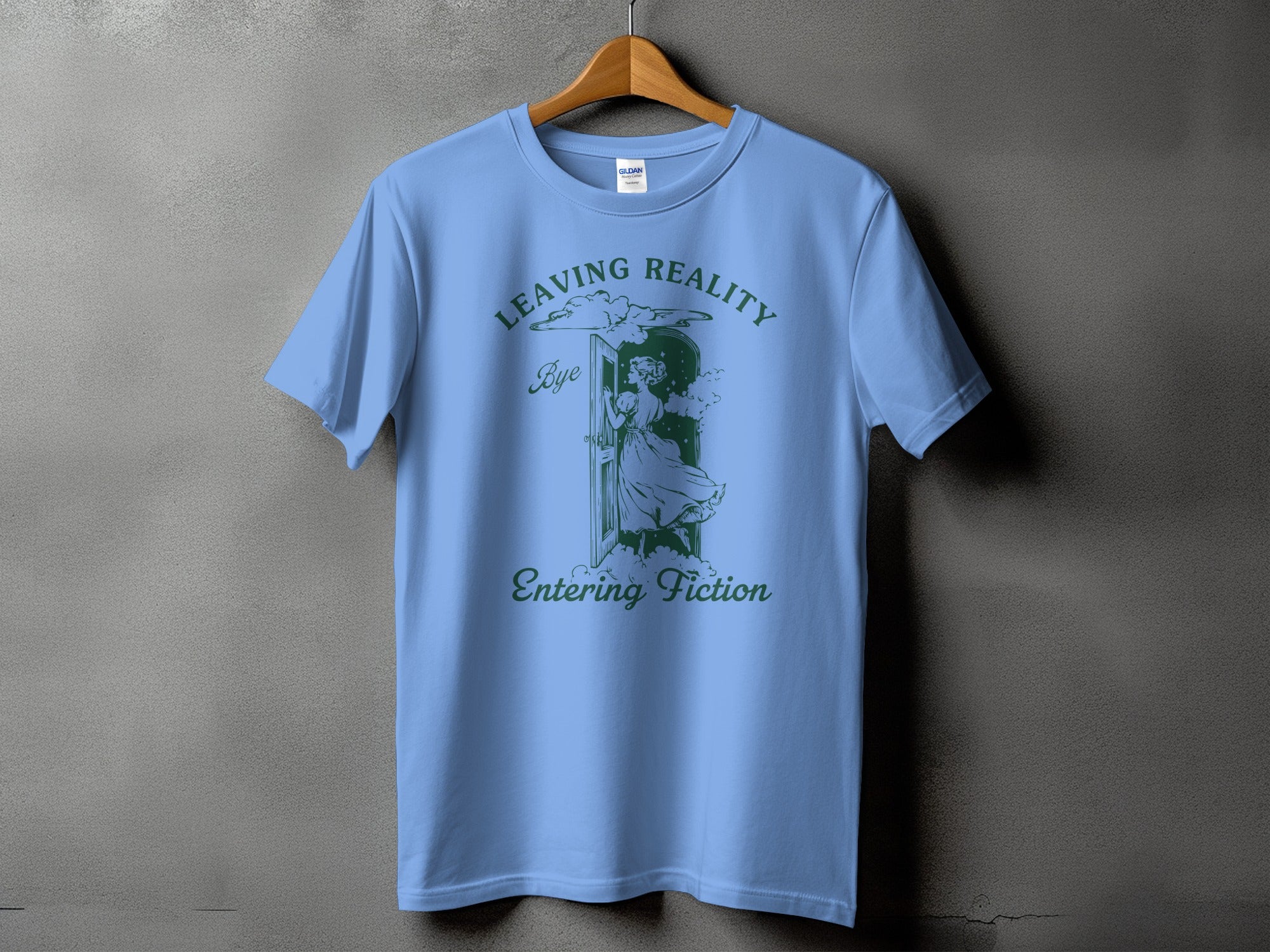 Light blue t-shirt with a dark green graphic of a doorway and text "Leaving Reality Bye Entering Fiction".
