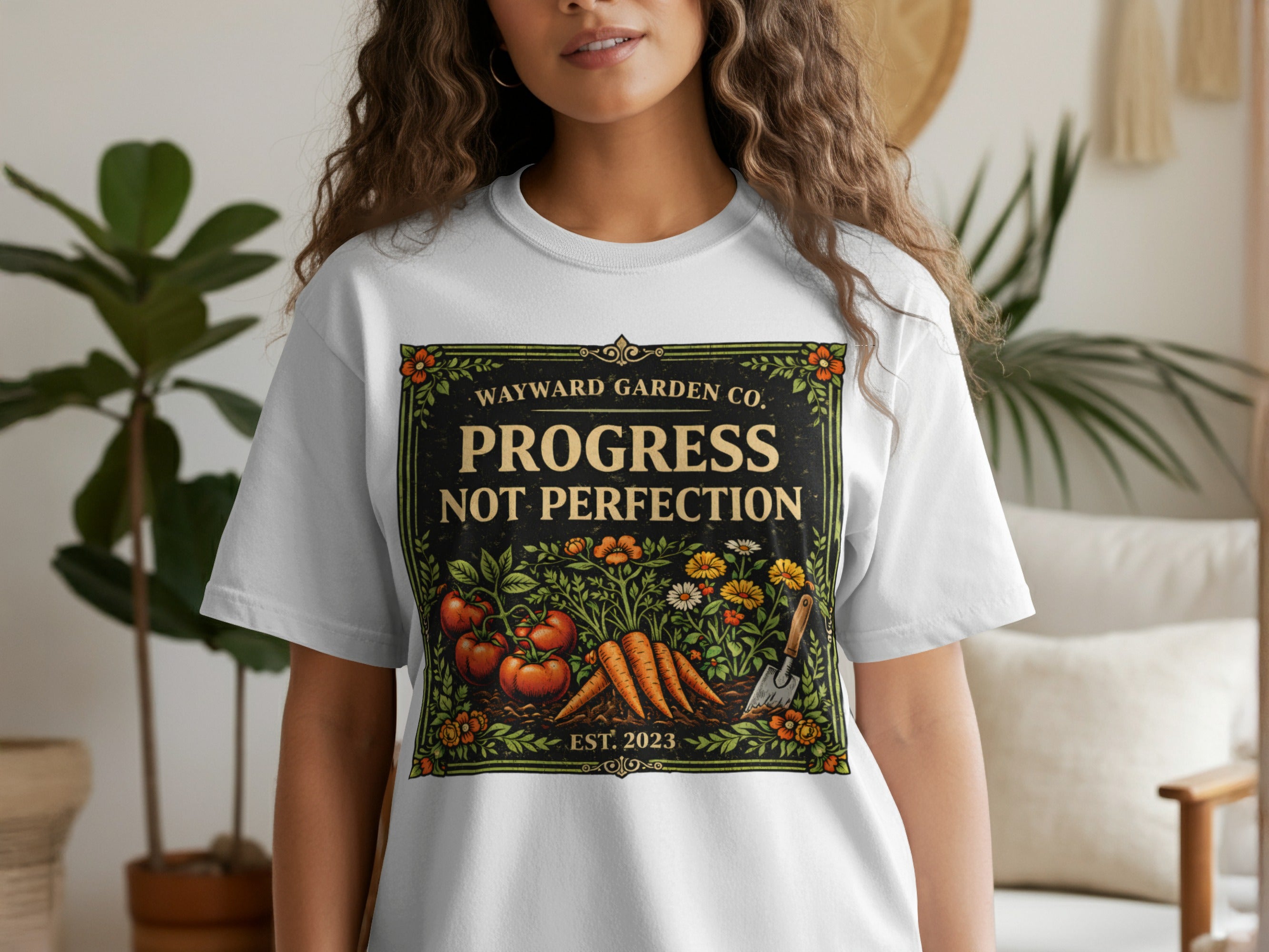 White t-shirt with "Progress Not Perfection" garden design featuring tomatoes and carrots.