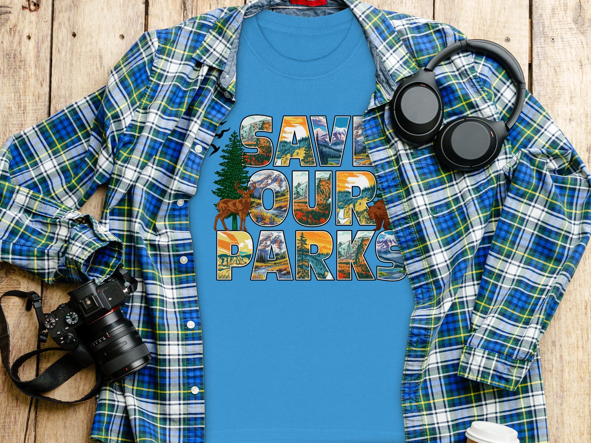 Blue t-shirt with "Save Our Parks" graphic, plaid shirt, headphones, and camera.