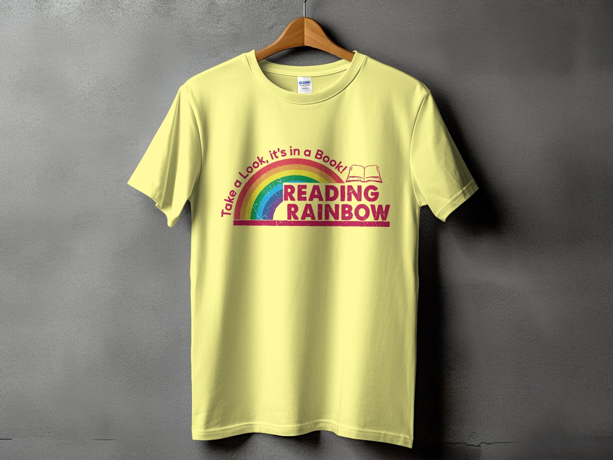 Light yellow t-shirt with rainbow and "Reading Rainbow" text graphic.