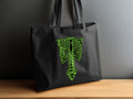 Black tote bag with a lime green skeleton ribcage and spine design.