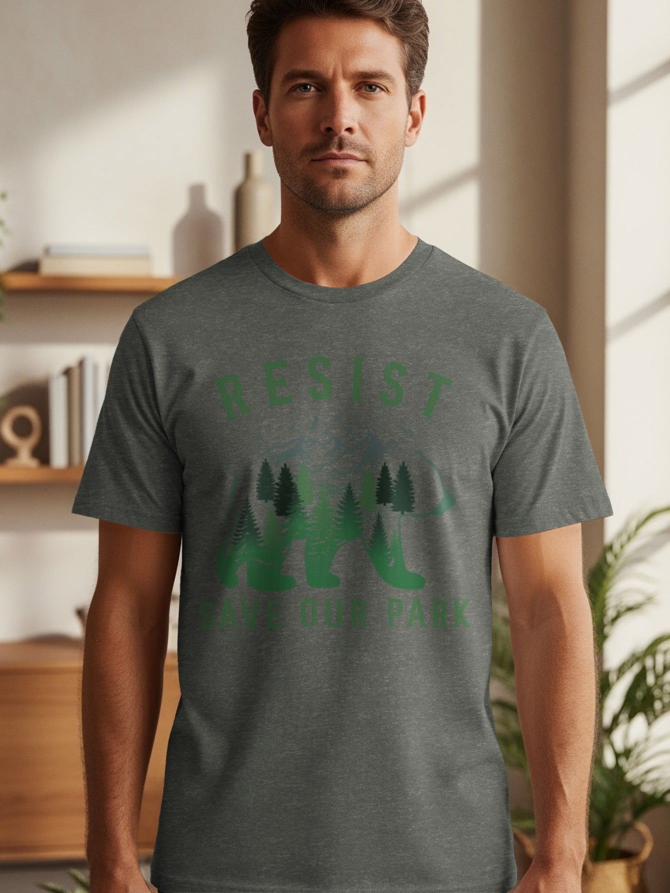 Man wearing dark grey t-shirt with green "RESIST SAVE OUR PARK" text and bear graphic.