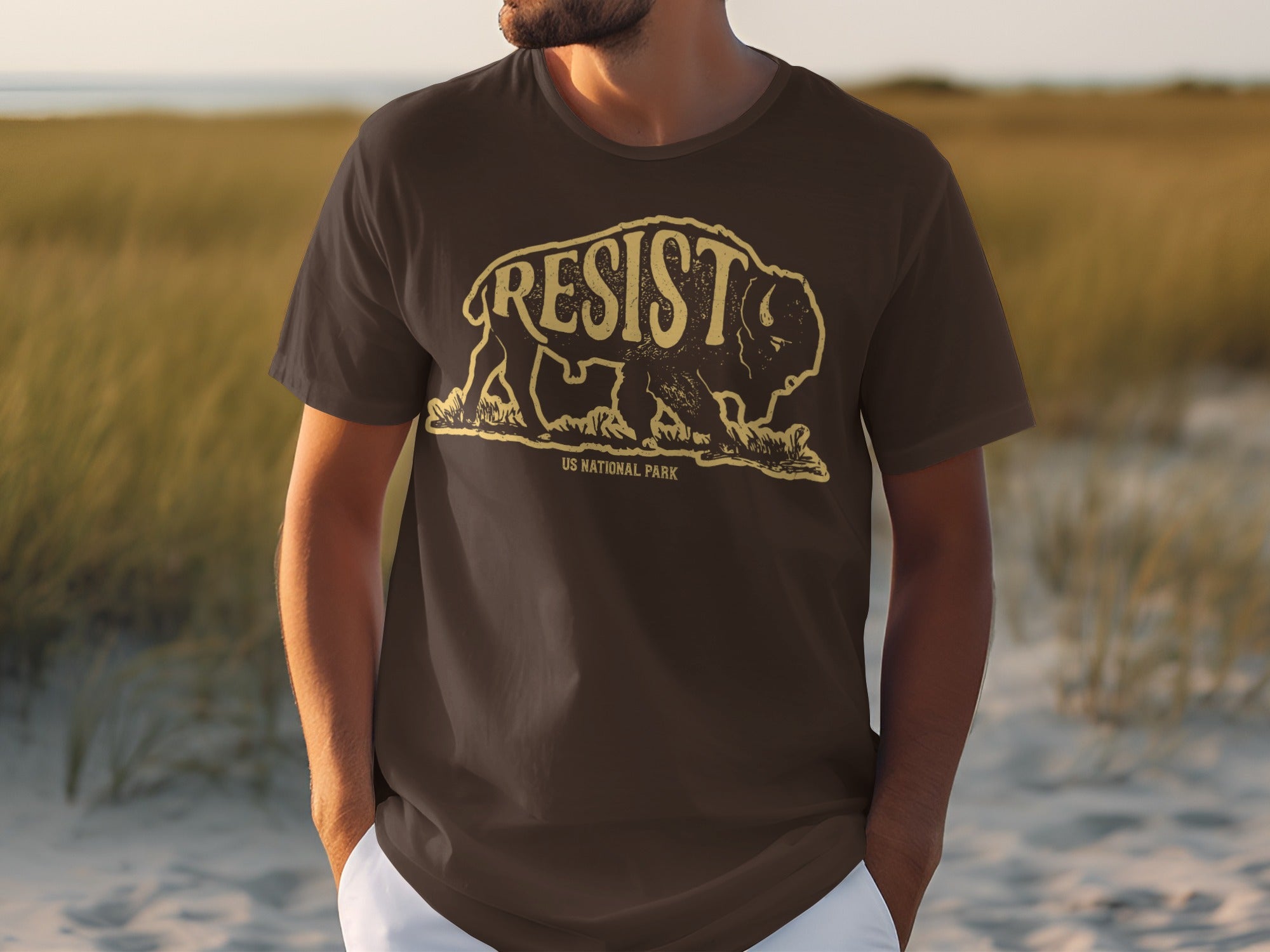 Brown t-shirt with distressed bison graphic and "RESIST US NATIONAL PARK" text.