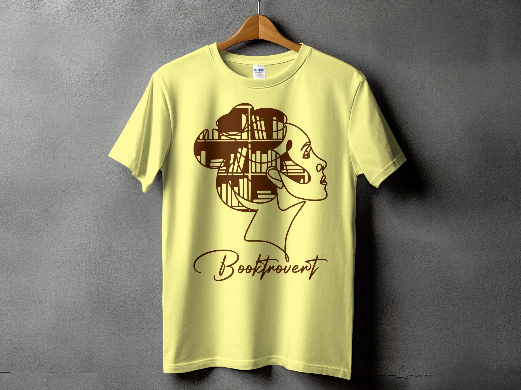 Light yellow t-shirt with brown outline of a woman's profile and the text "Booktrovert".