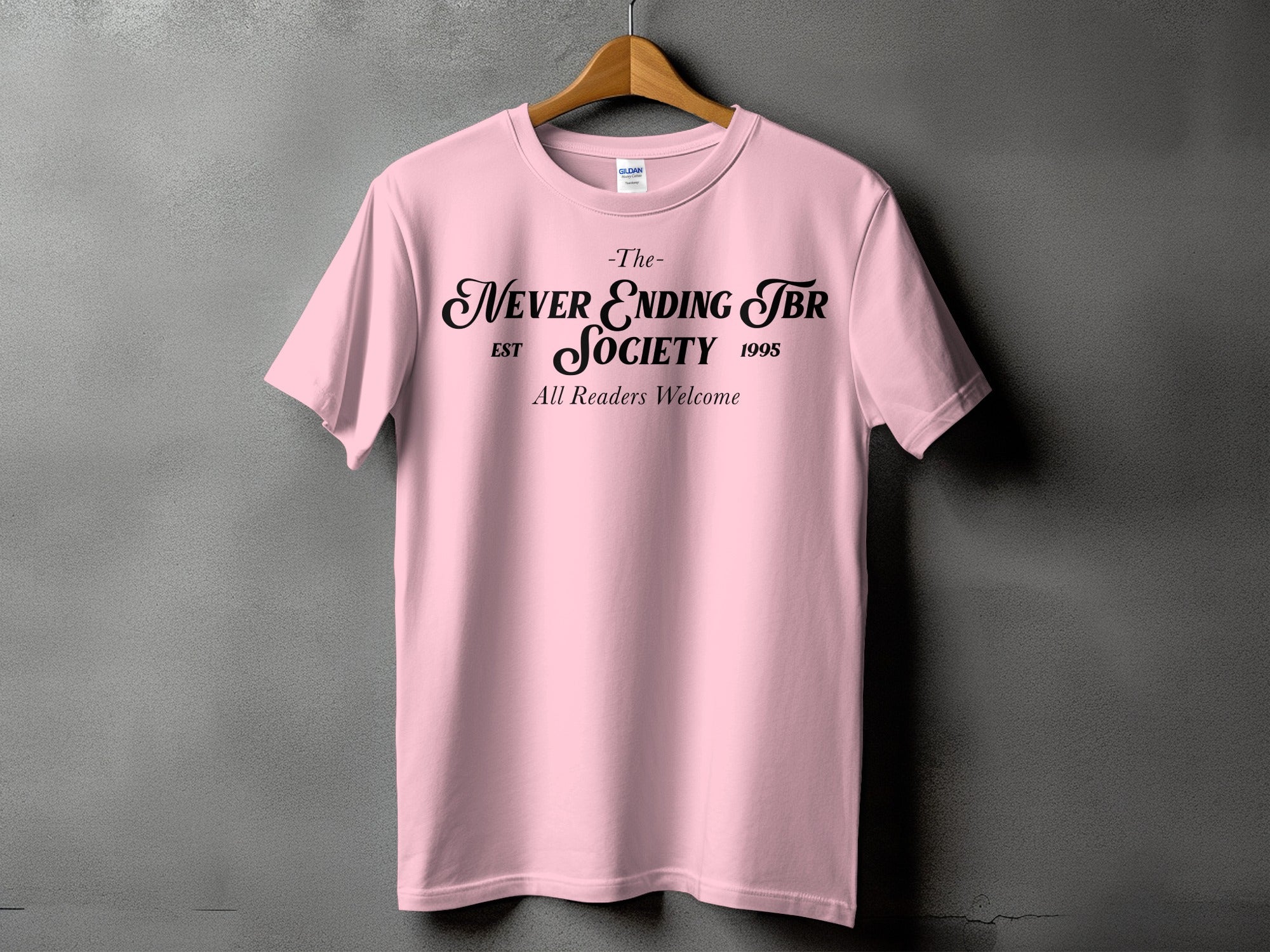 Pink t-shirt with black text "The Never Ending TBR Society EST 1995 All Readers Welcome".
