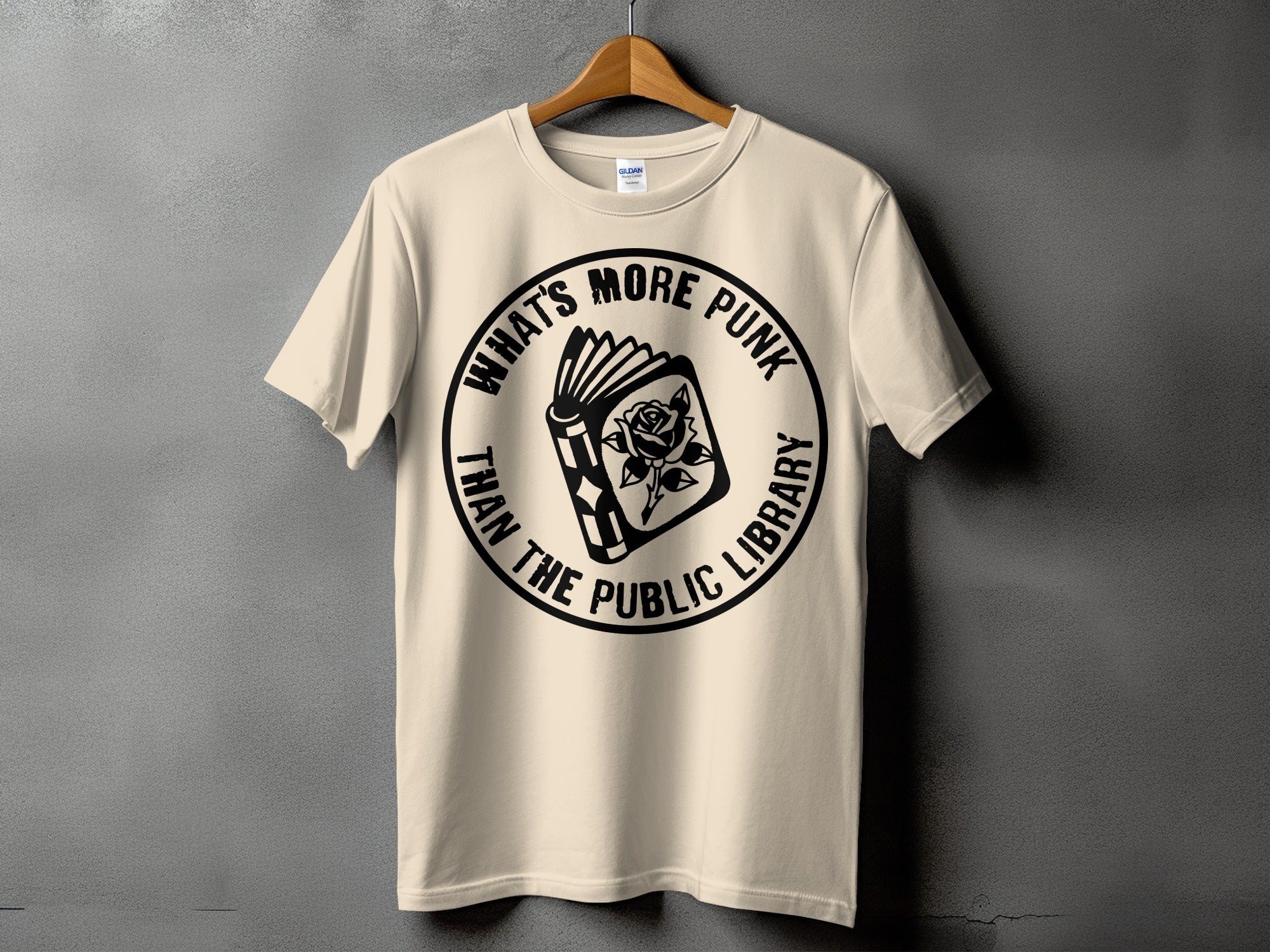 Cream t-shirt with circular graphic: open book with rose, "What's More Punk Than The Public Library"