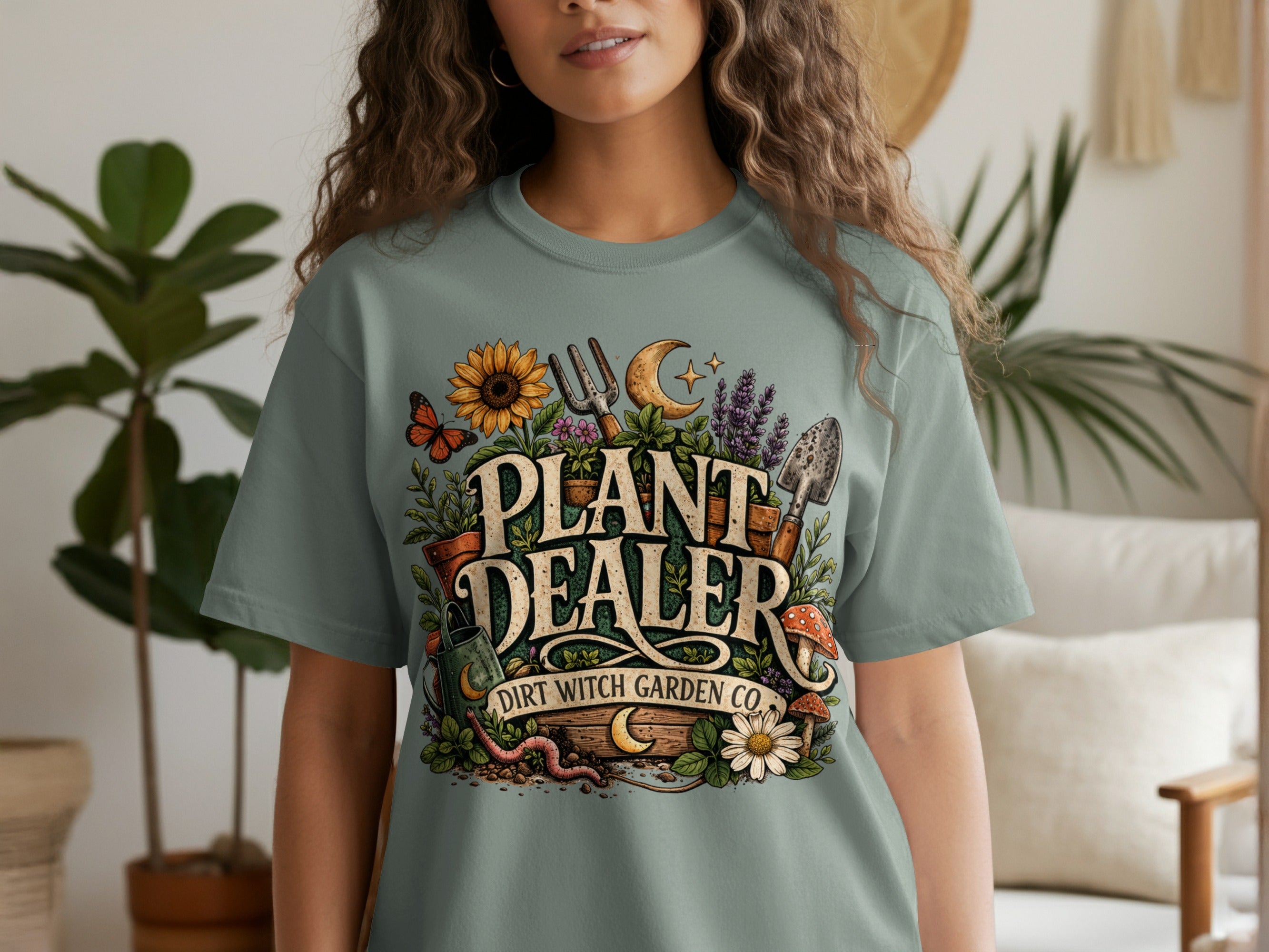 "Plant Dealer Dirt Witch Garden Co." text on a t-shirt with gardening imagery.