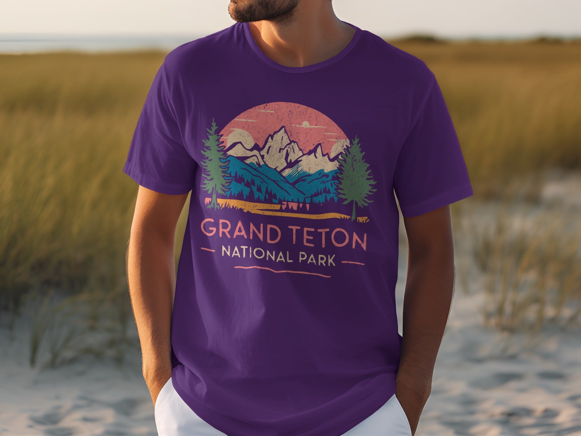 Purple t-shirt with Grand Teton National Park design featuring mountains, trees, and sunset.