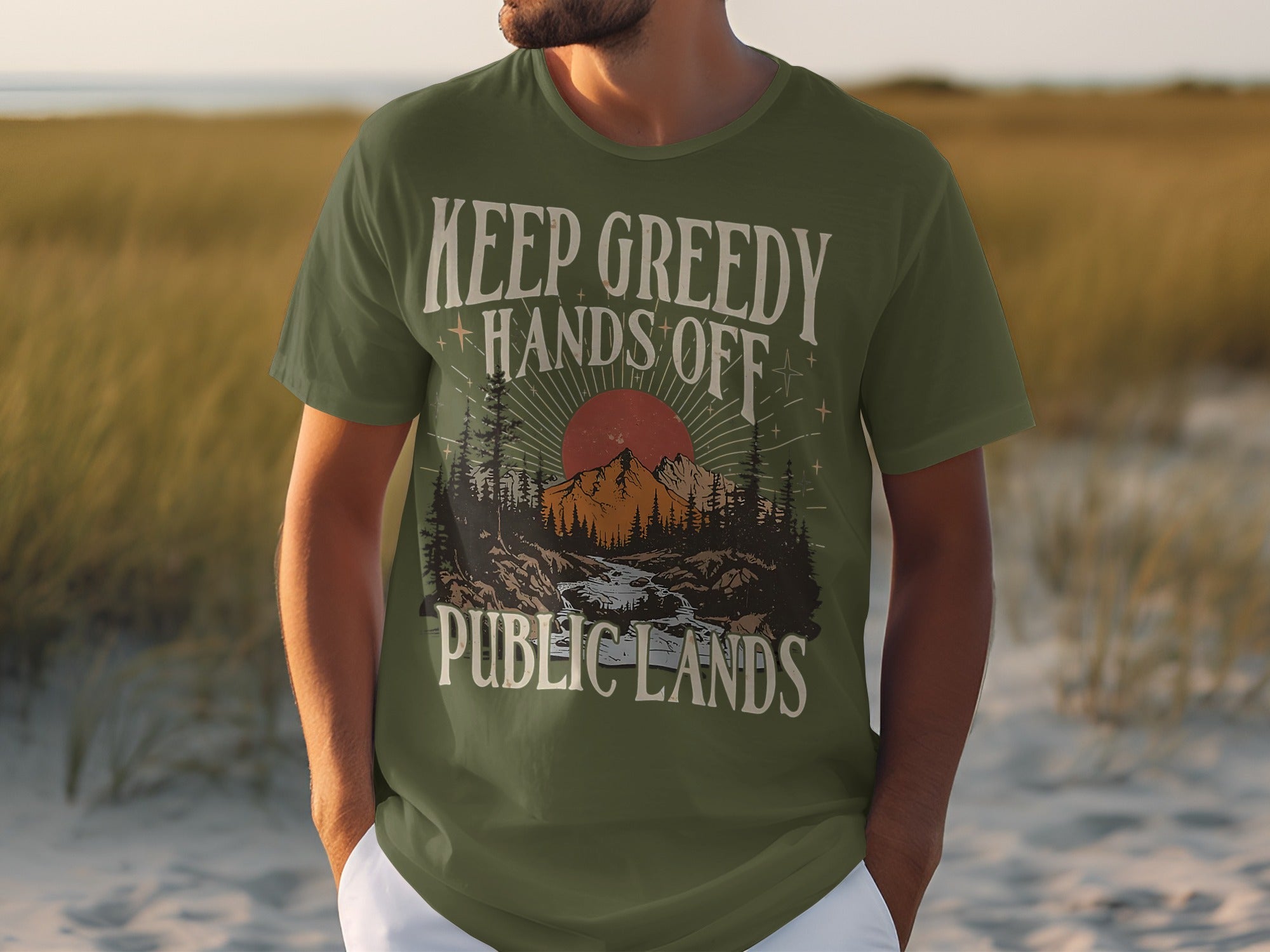 Green t-shirt with "Keep Greedy Hands Off Public Lands" text and wilderness graphic.