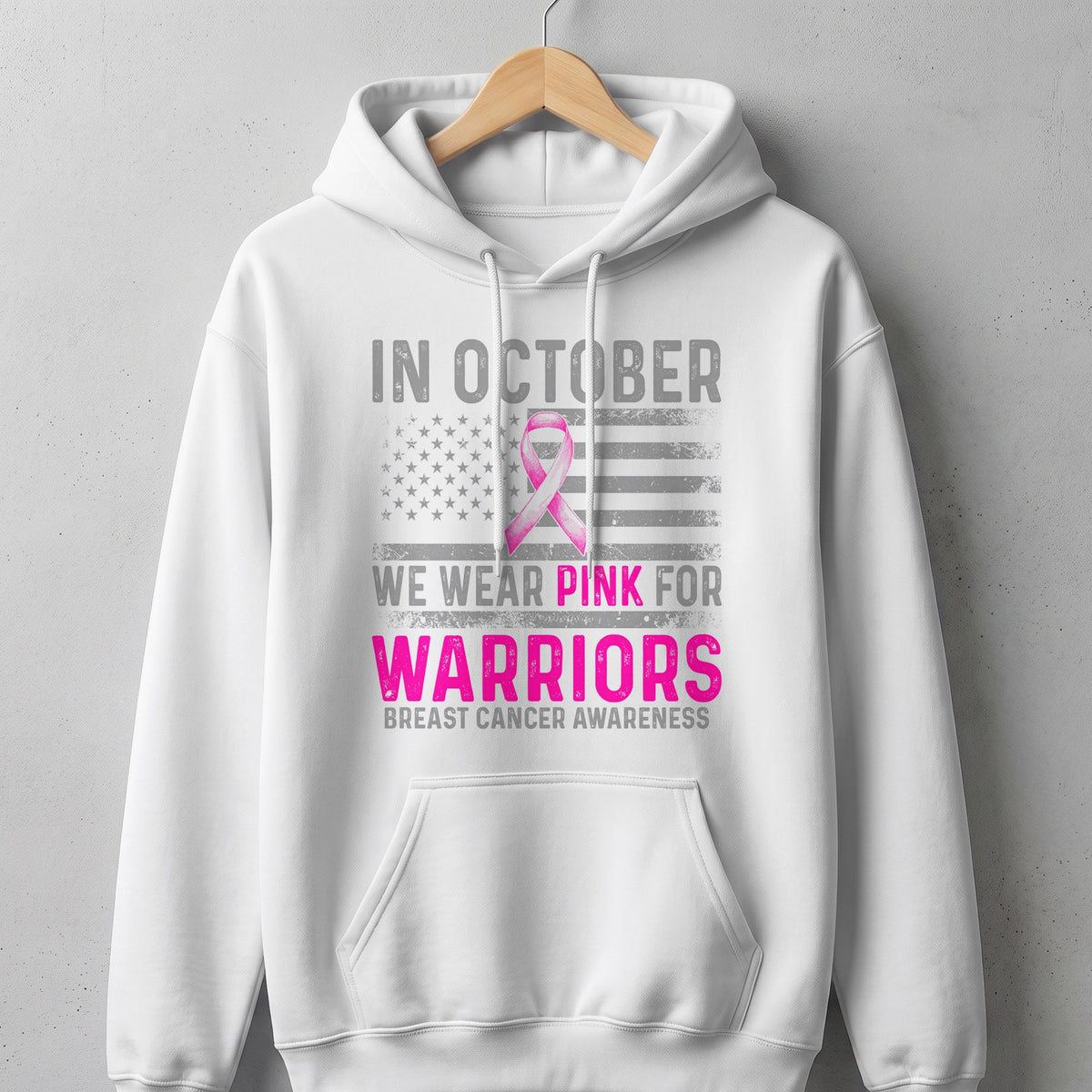 White hoodie with "In October We Wear Pink For Warriors" breast cancer awareness graphic.