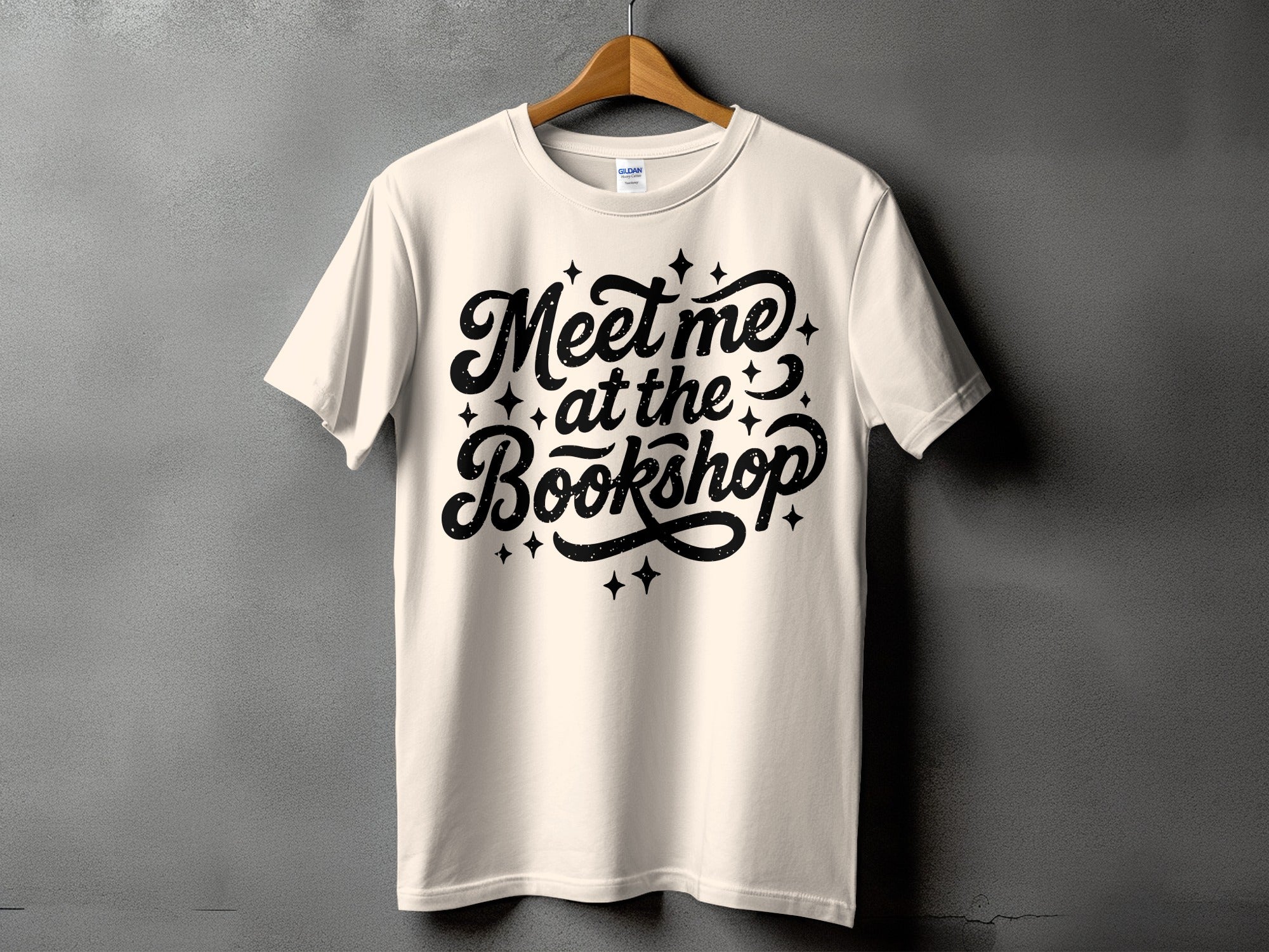 Cream t-shirt with black text "Meet me at the Bookshop" and sparkles.