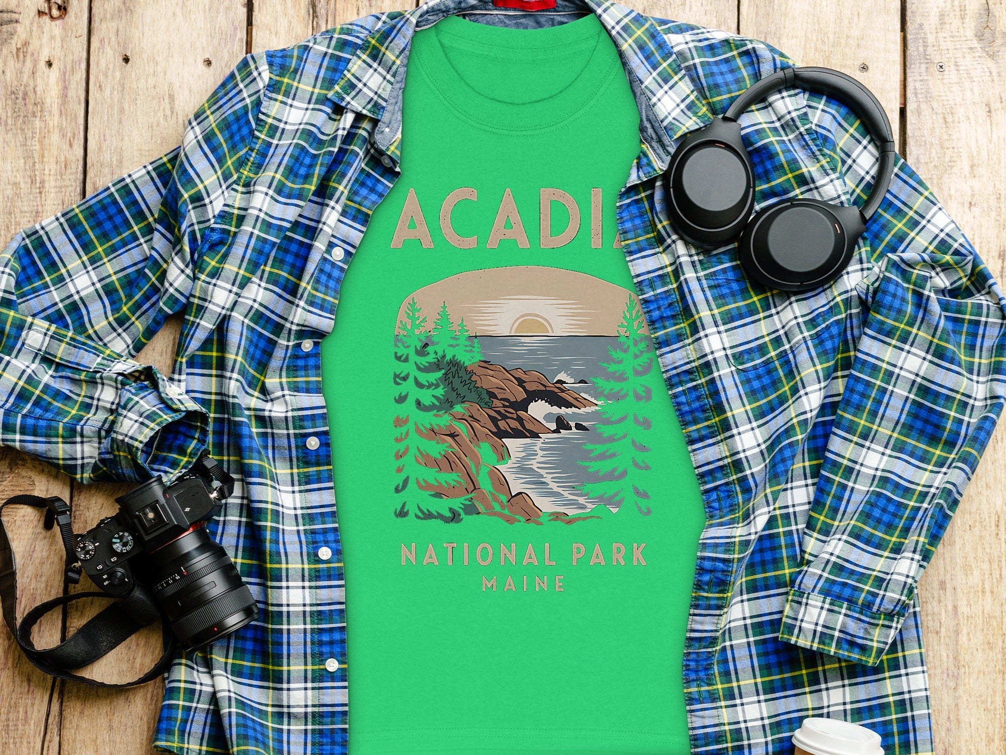 Green Acadia National Park Maine t-shirt with graphic and open plaid shirt.