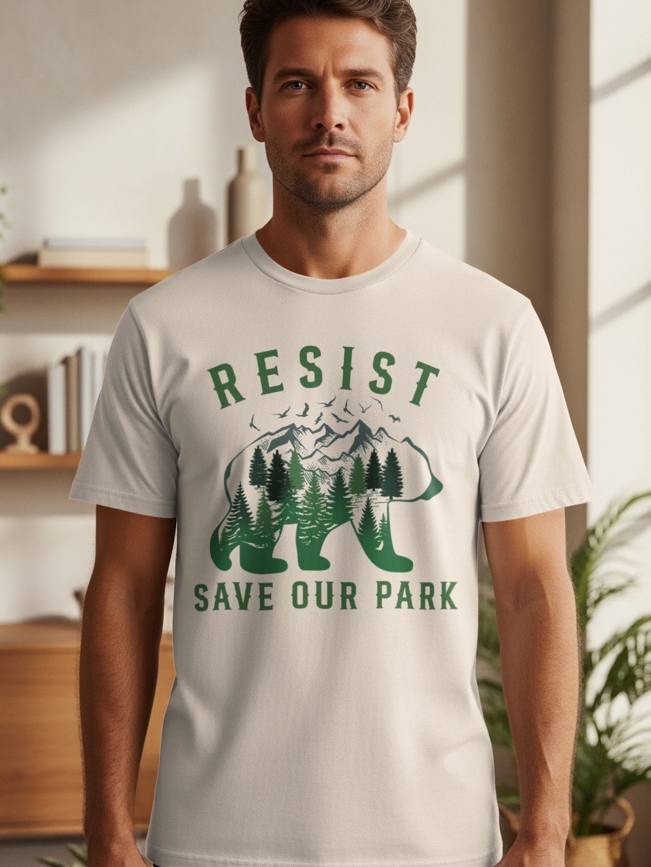 Men's light t-shirt with green text and a bear silhouette filled with trees and mountains.