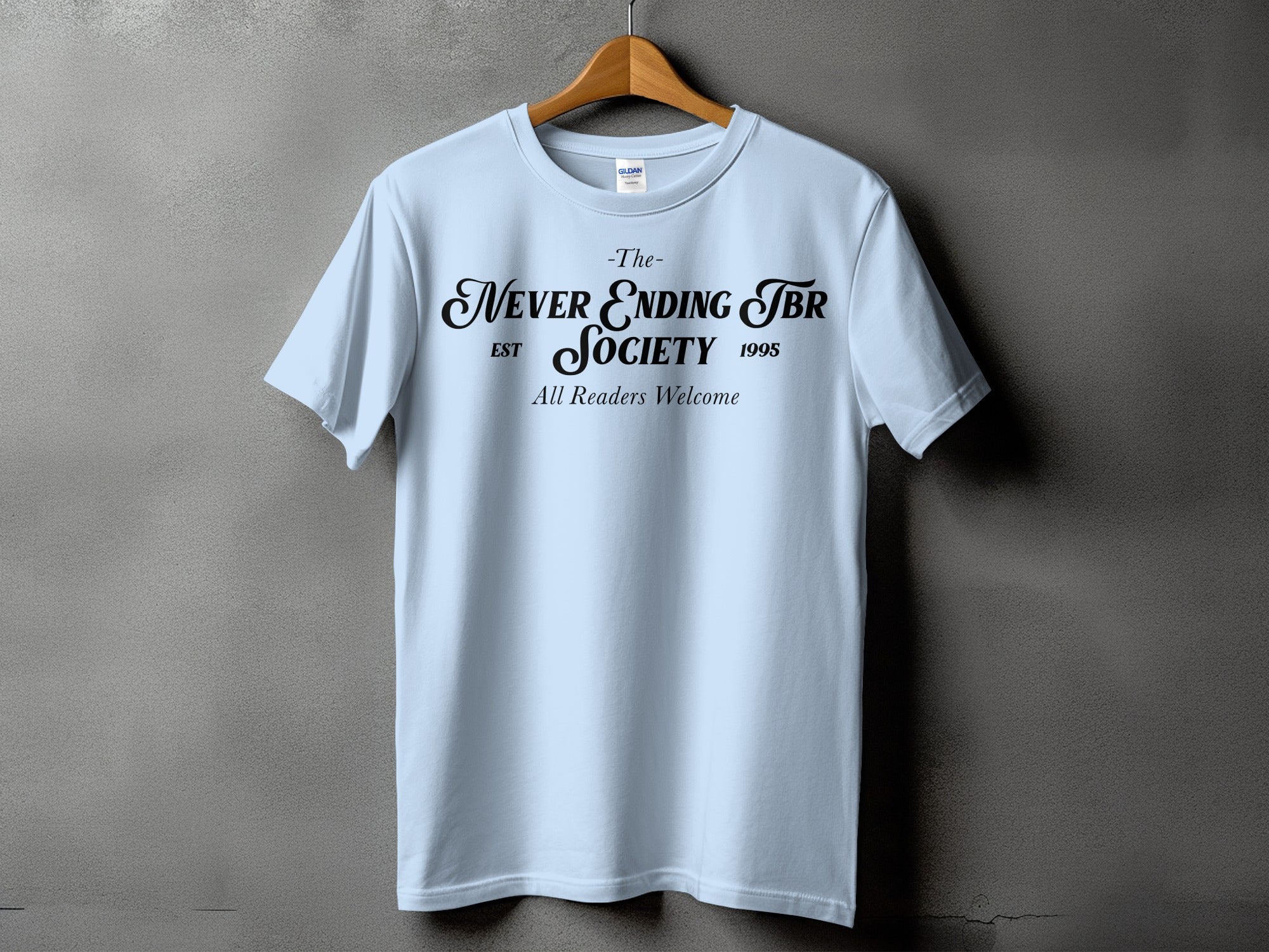Light blue t-shirt with black text: "The Never Ending TBR Society Est 1995 All Readers Welcome".