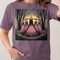 Five witches in pink dresses and hats stand in a dark forest at sunset.