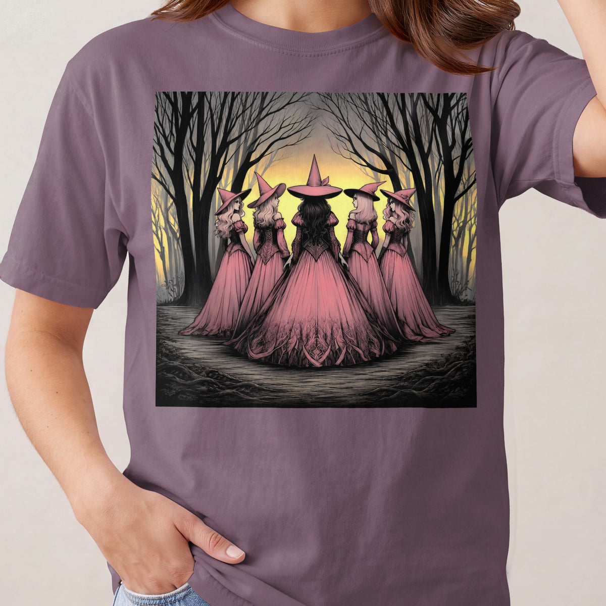 Five witches in pink dresses and hats stand in a dark forest at sunset.